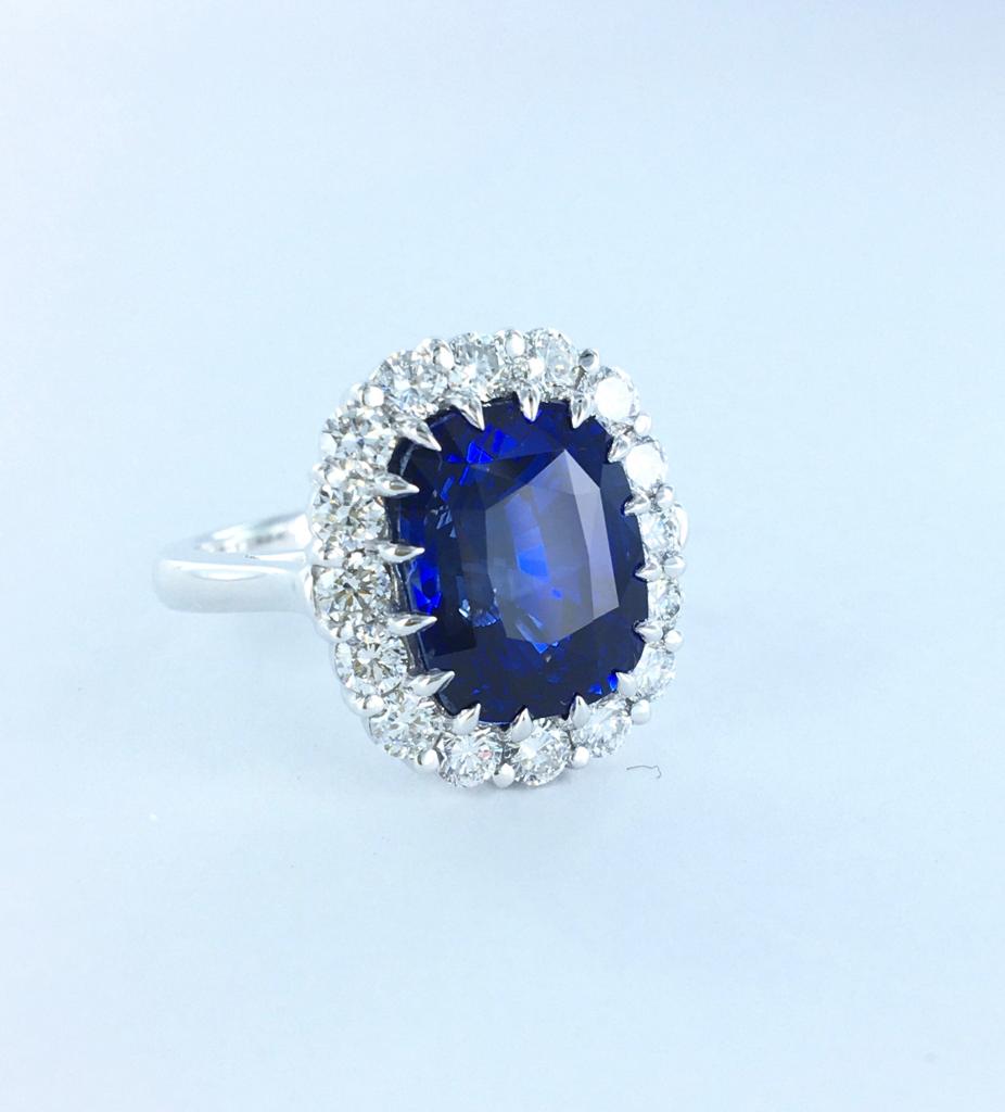 Elegant natural blue sapphire engagement ring in a classic halo setting.