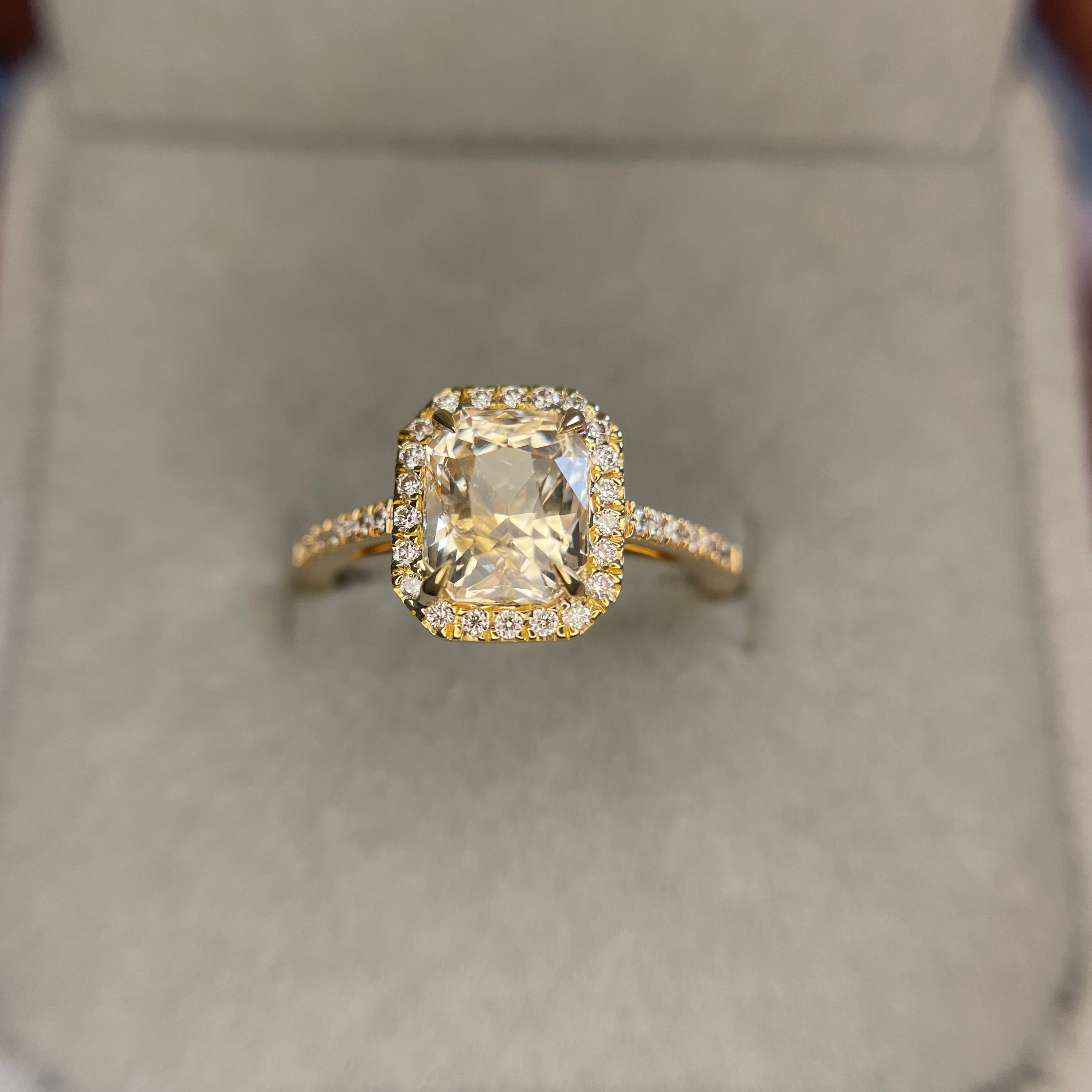 radiant cut peach sapphire in gold halo setting