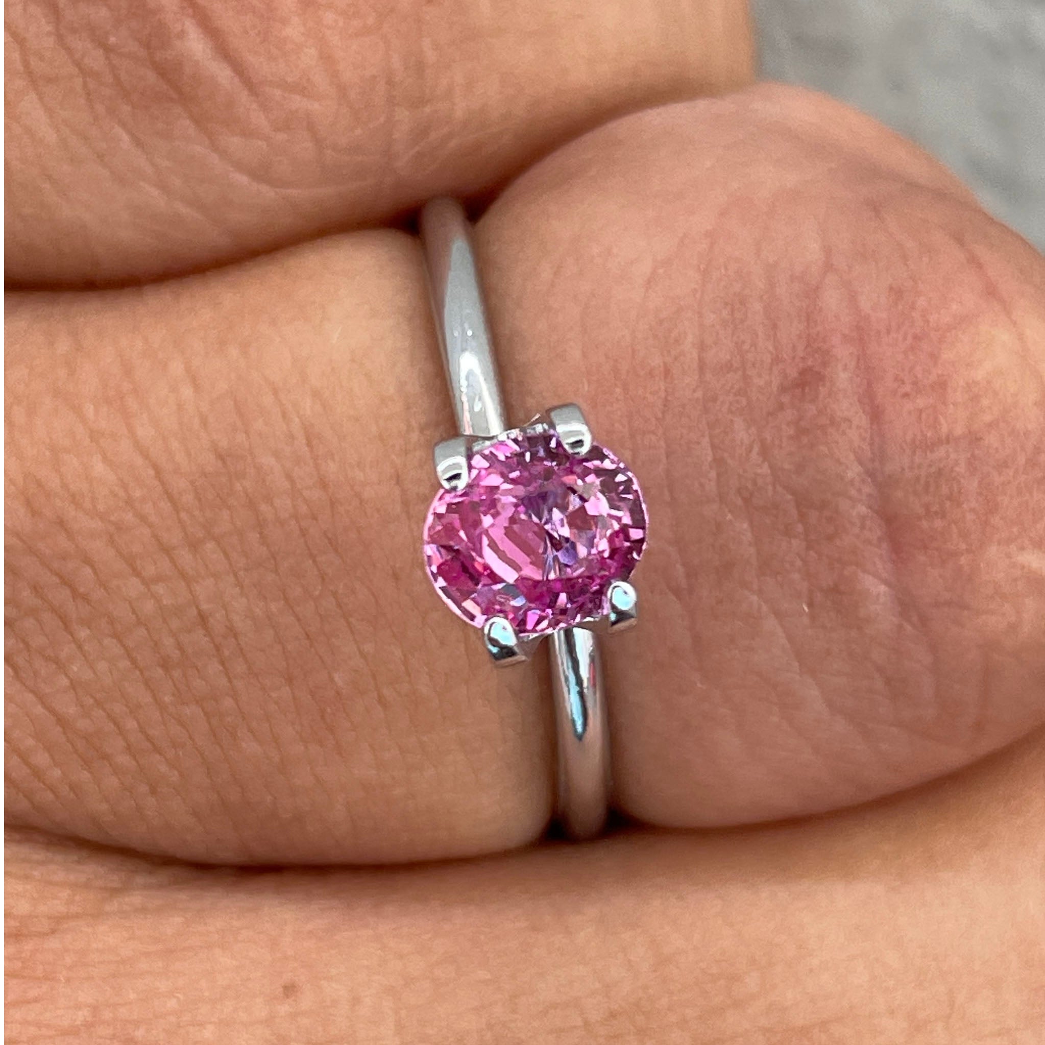 Pastel pink peach sapphire engagement ring in oval cut setting