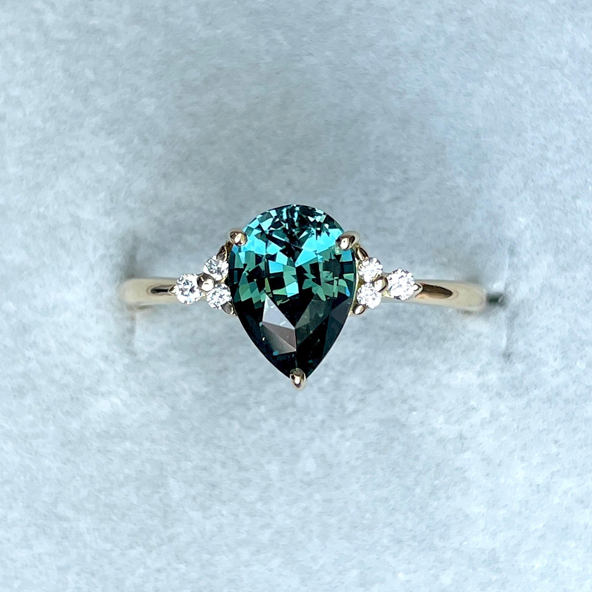 Teal sapphire engagement ring with gold setting