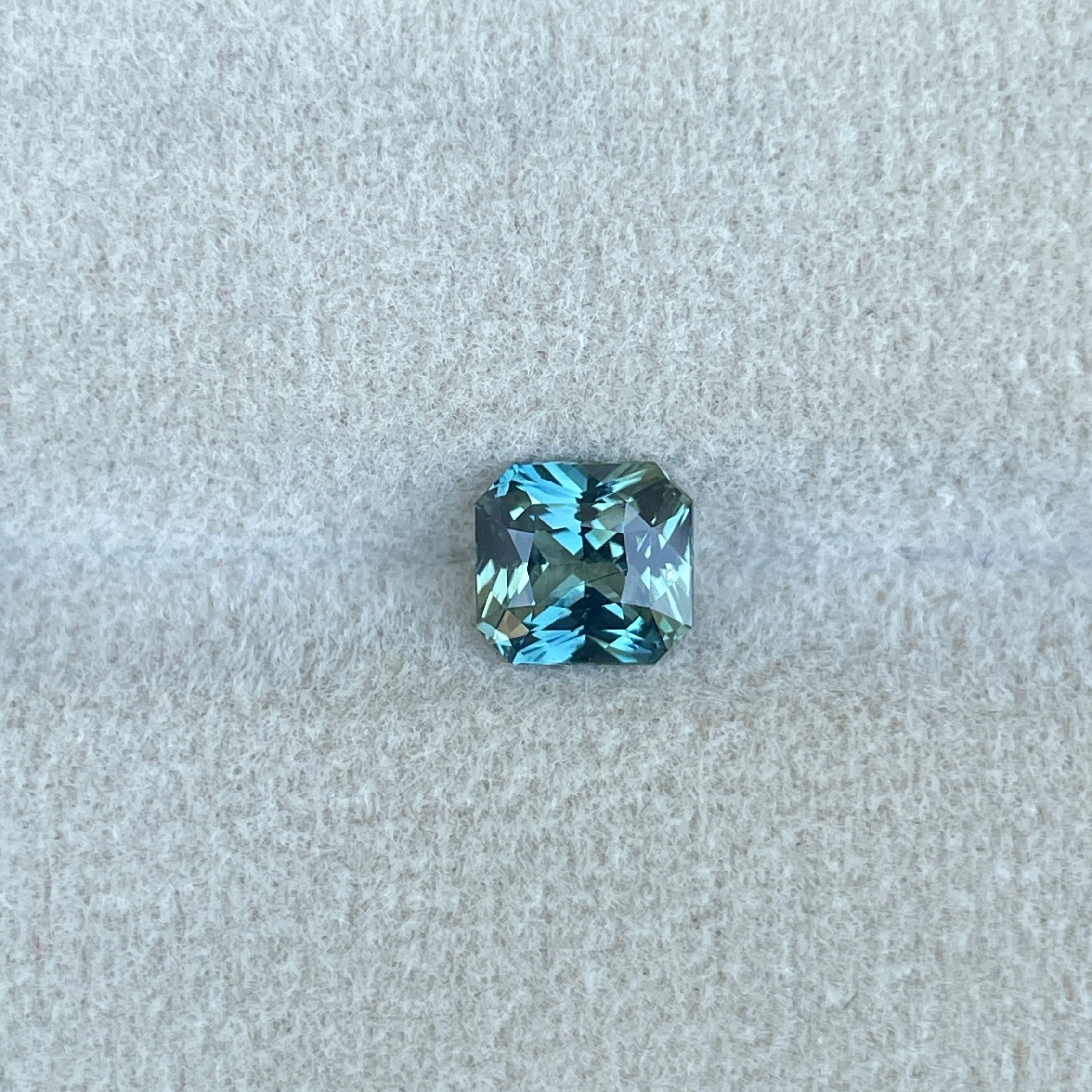 Loose teal sapphire gemstone in natural lighting