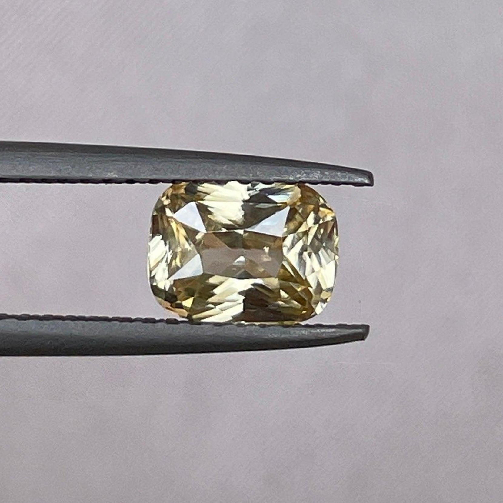 Natural yellow sapphire 1.60 ct. with yellowish peach hue from NASHGEMS, showcasing its vibrant color and smooth cut.