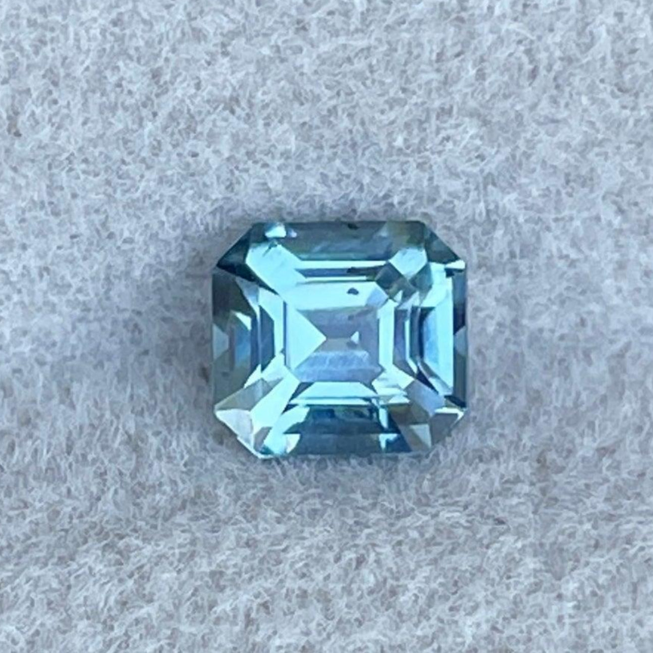 Teal sapphire gemstone from NASHGEMS, 0.78 carats, bluish-green color, ideal for engagement rings or green jewelry necklaces.