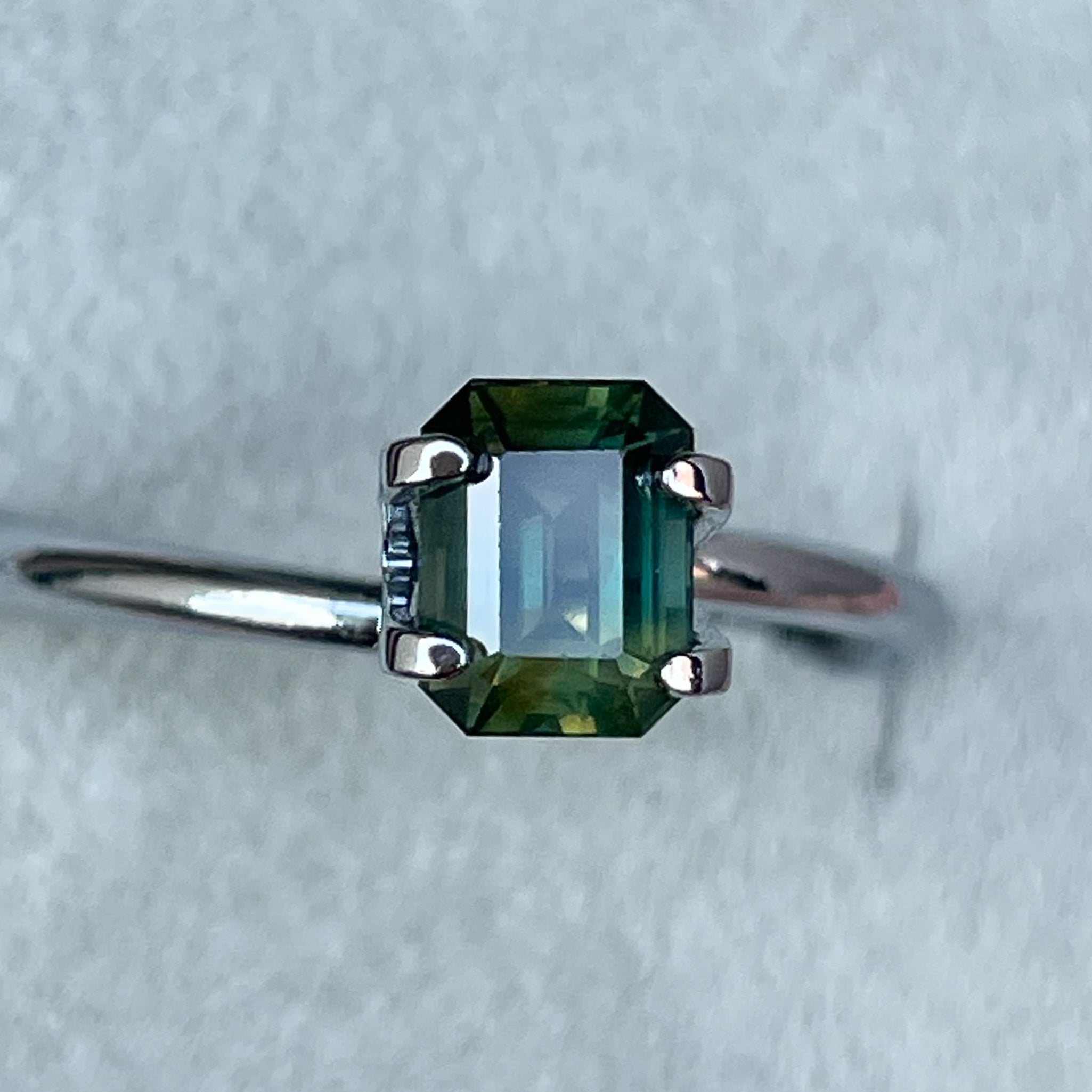Teal natural bi-color sapphire, 1.13 Ct emerald cut loose gemstone by NASHGEMS, ideal for engagement or custom jewelry.