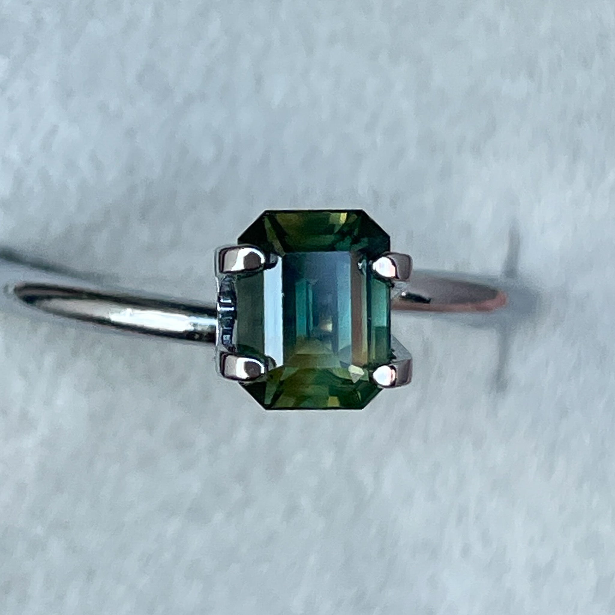 Teal natural bi-color sapphire 1.13 ct emerald cut loose gemstone by NASHGEMS, ideal for engagement rings or custom jewelry.