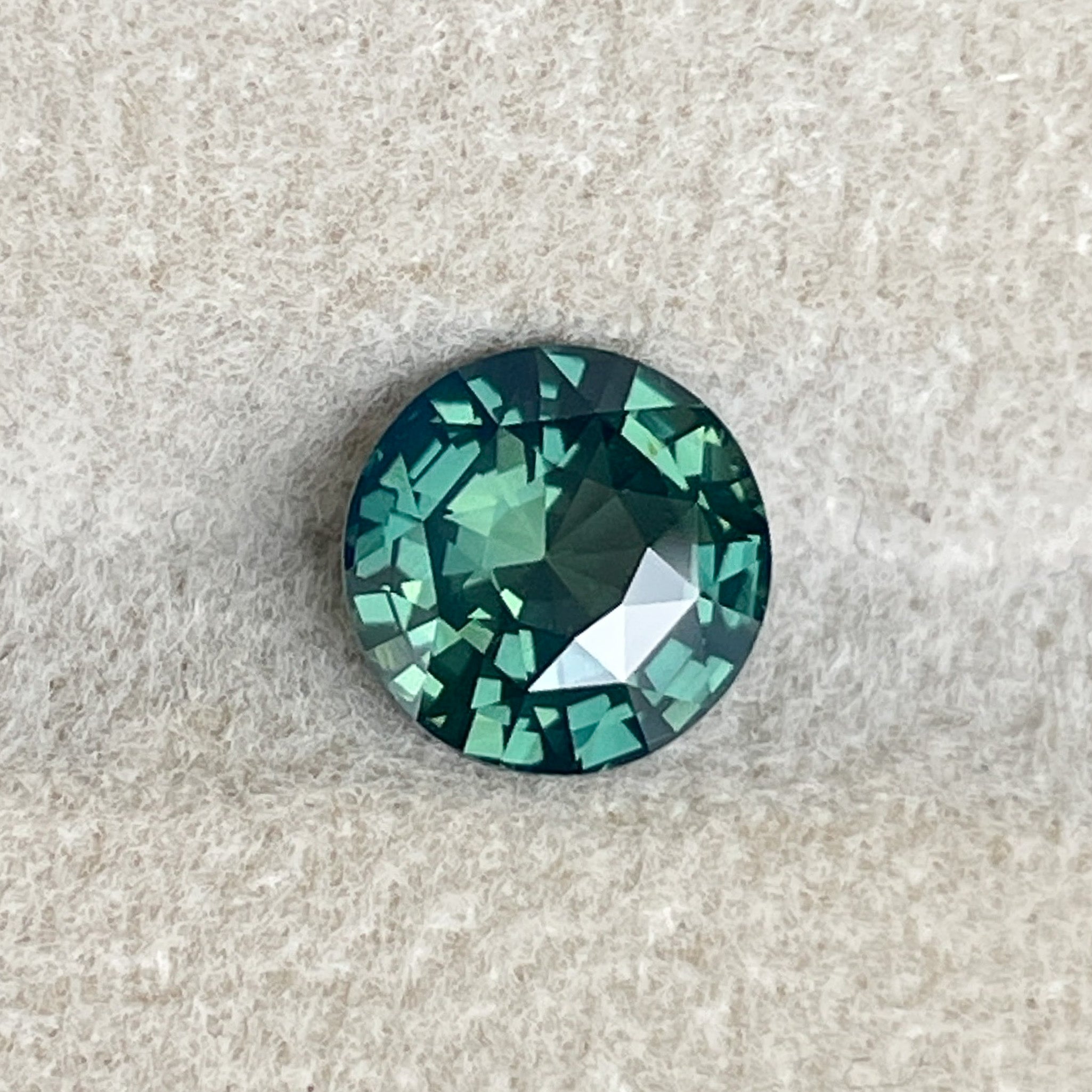 Natural forest green sapphire, 1.83 Ct round cut teal gemstone from NASHGEMS, ideal for engagement rings or custom jewelry.