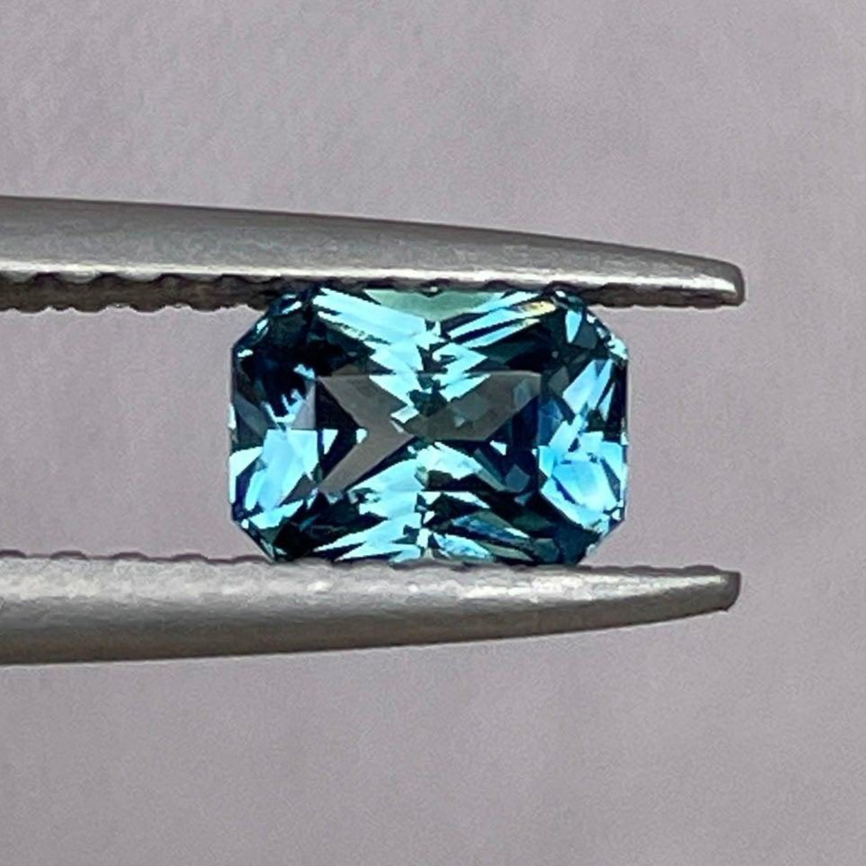 Loose teal sapphire with emerald cut, 0.81 carats, from NASHGEMS, showcasing vibrant teal and green-blue hues similar to Montana Yogo sapphires.