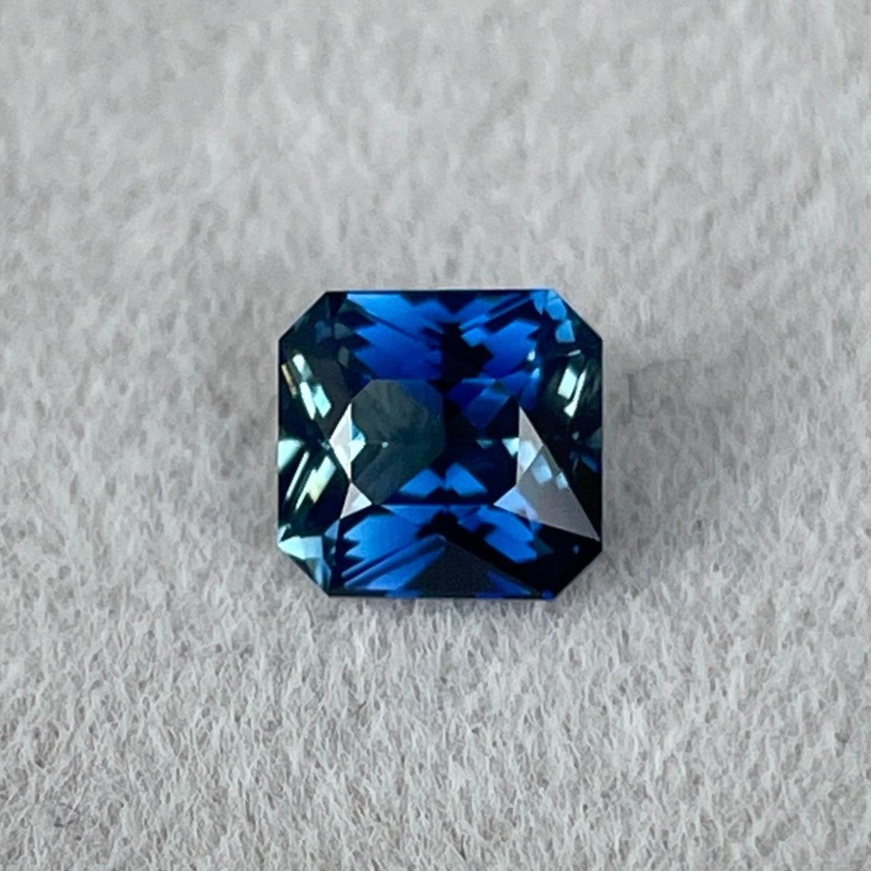 Teal sapphire with 1.23 ct blue-green bicolored radiant cut for engagement ring, showcasing rich bluish-green and greenish-blue hues.