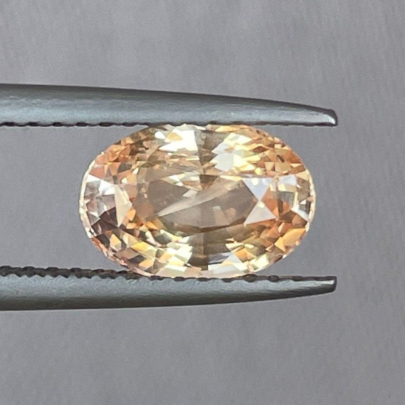 Oval peach sapphire engagement ring featuring a 2.10 carat champagne sapphire in white gold setting by NASHGEMS.