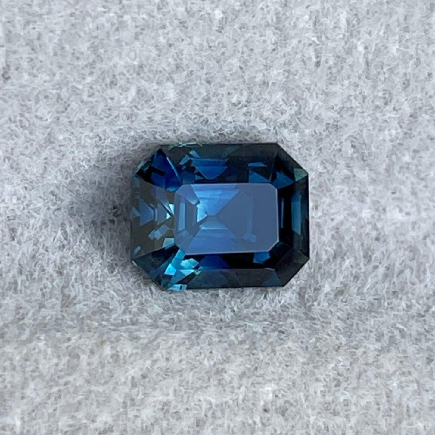 Teal sapphire engagement ring with emerald cut teal gemstone, 1.13 carats, set in silver jewelry by NASHGEMS.