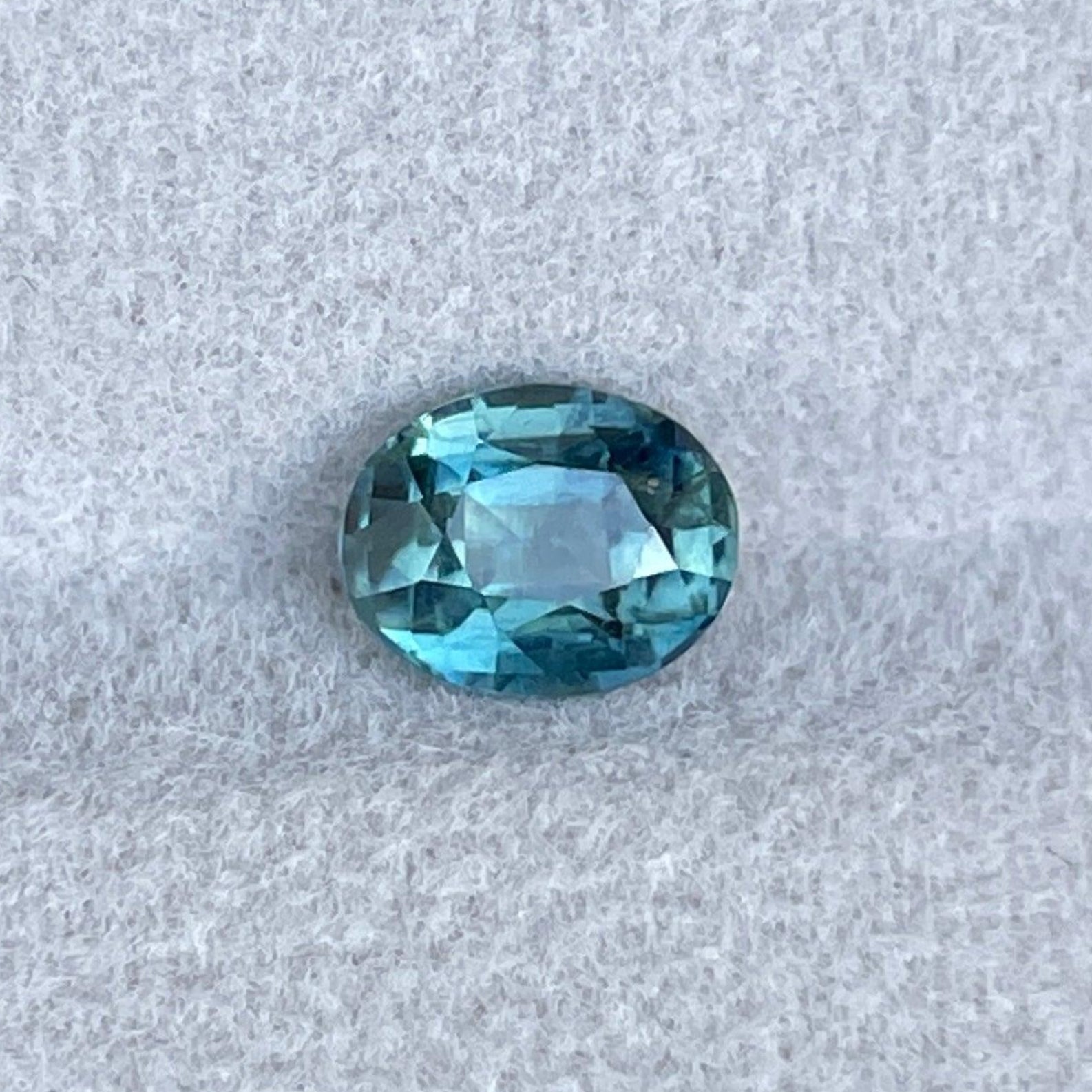 Teal sapphire loose gemstone, oval cut, 1.38 carats, suitable for custom jewelry rings and pendants.