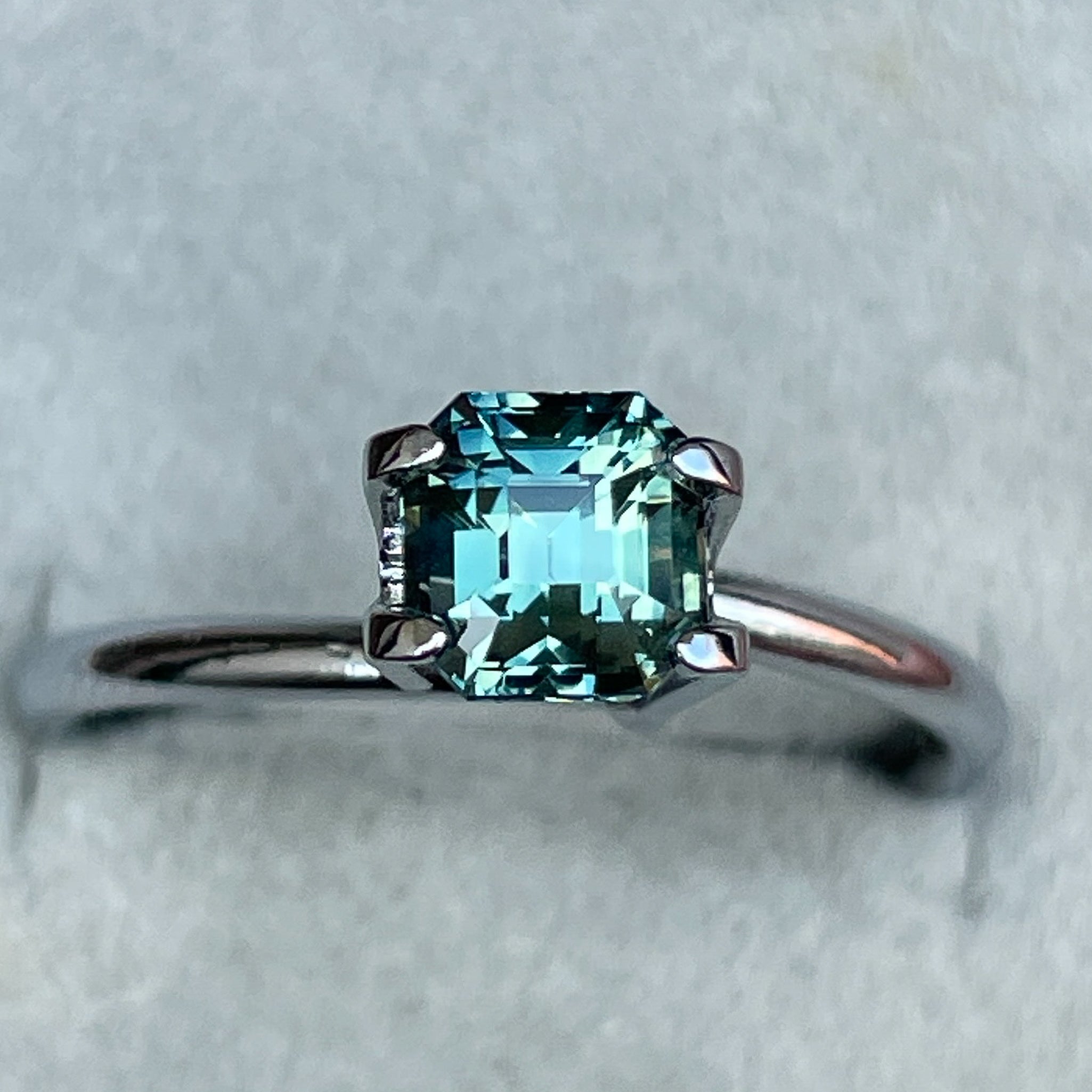 Natural teal green sapphire 1.36 Ct emerald cut, loose gemstone from NASHGEMS, ideal for engagement rings or custom jewelry.