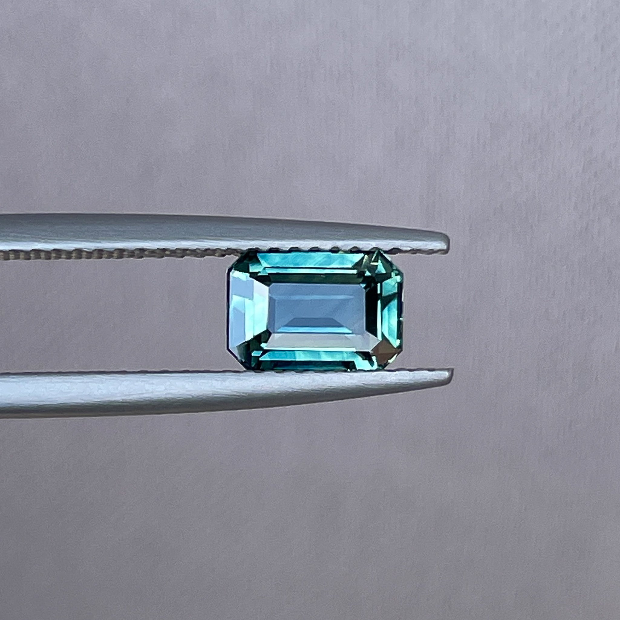 Natural teal sapphire loose stone, 1.52 ct emerald cut by NASHGEMS, showcasing vibrant blue-green gemstone for jewelry making.