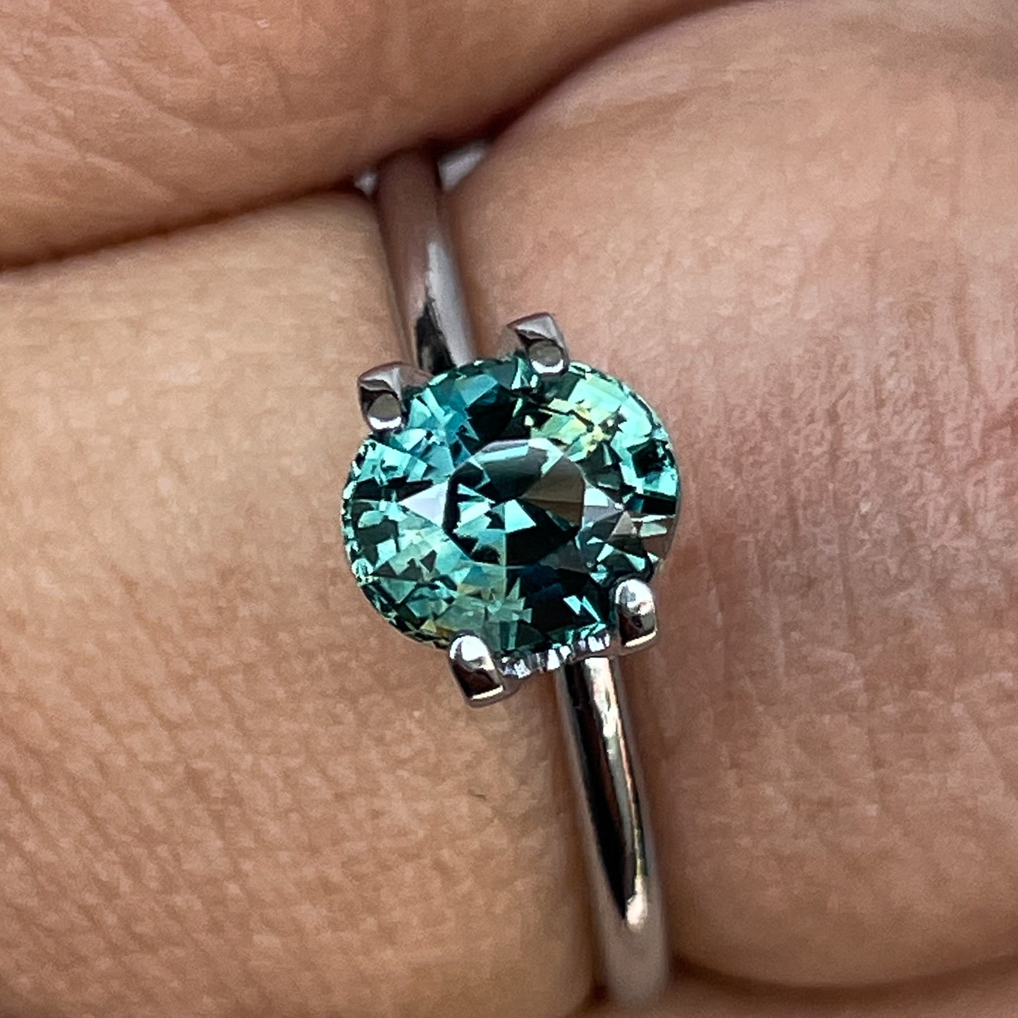 Teal blue-green oval cut sapphire from NASHGEMS, 1.56 Ct loose gemstone ideal for engagement rings or custom jewelry designs.