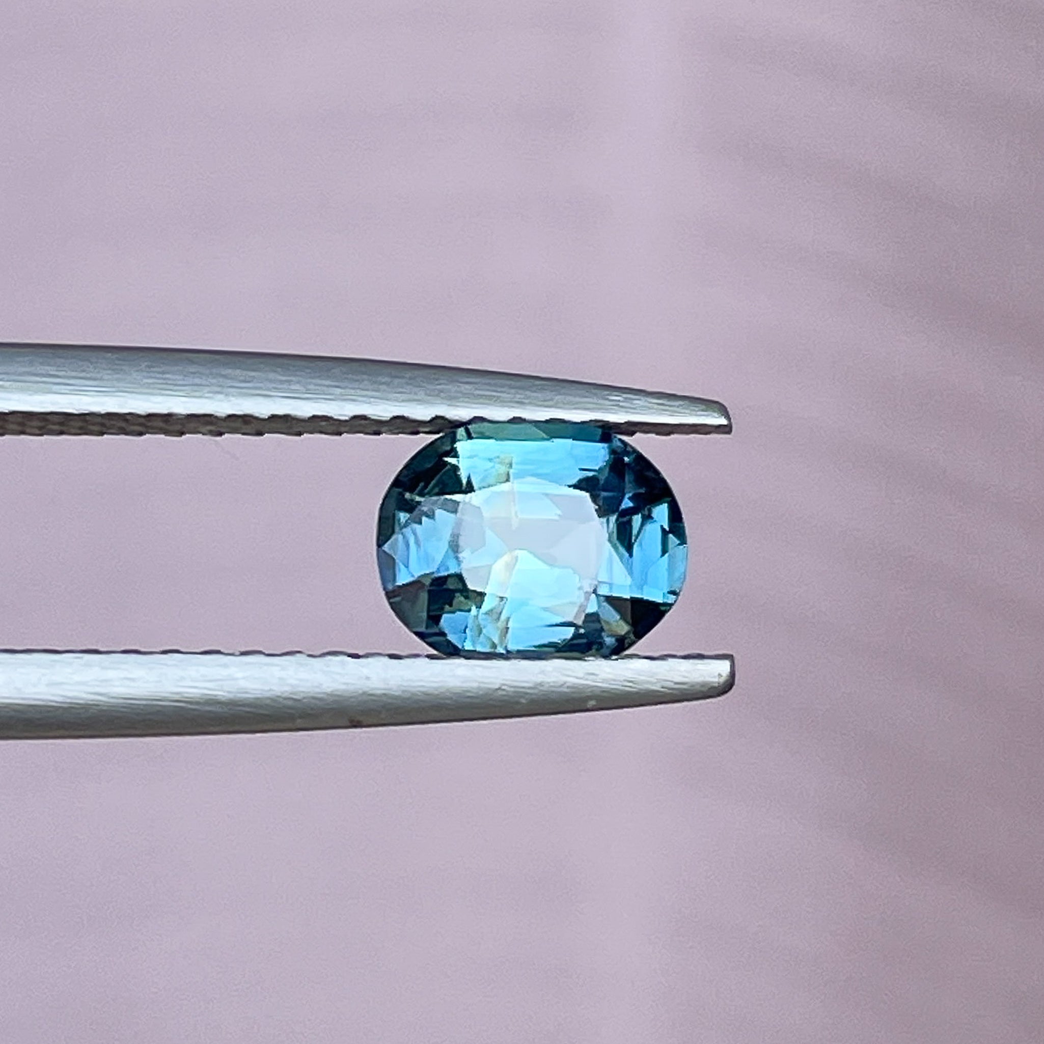 Natural teal sapphire loose stone, 1.03 Ct oval cut by NASHGEMS, featuring vibrant blue-green hues for jewelry or engagement rings.