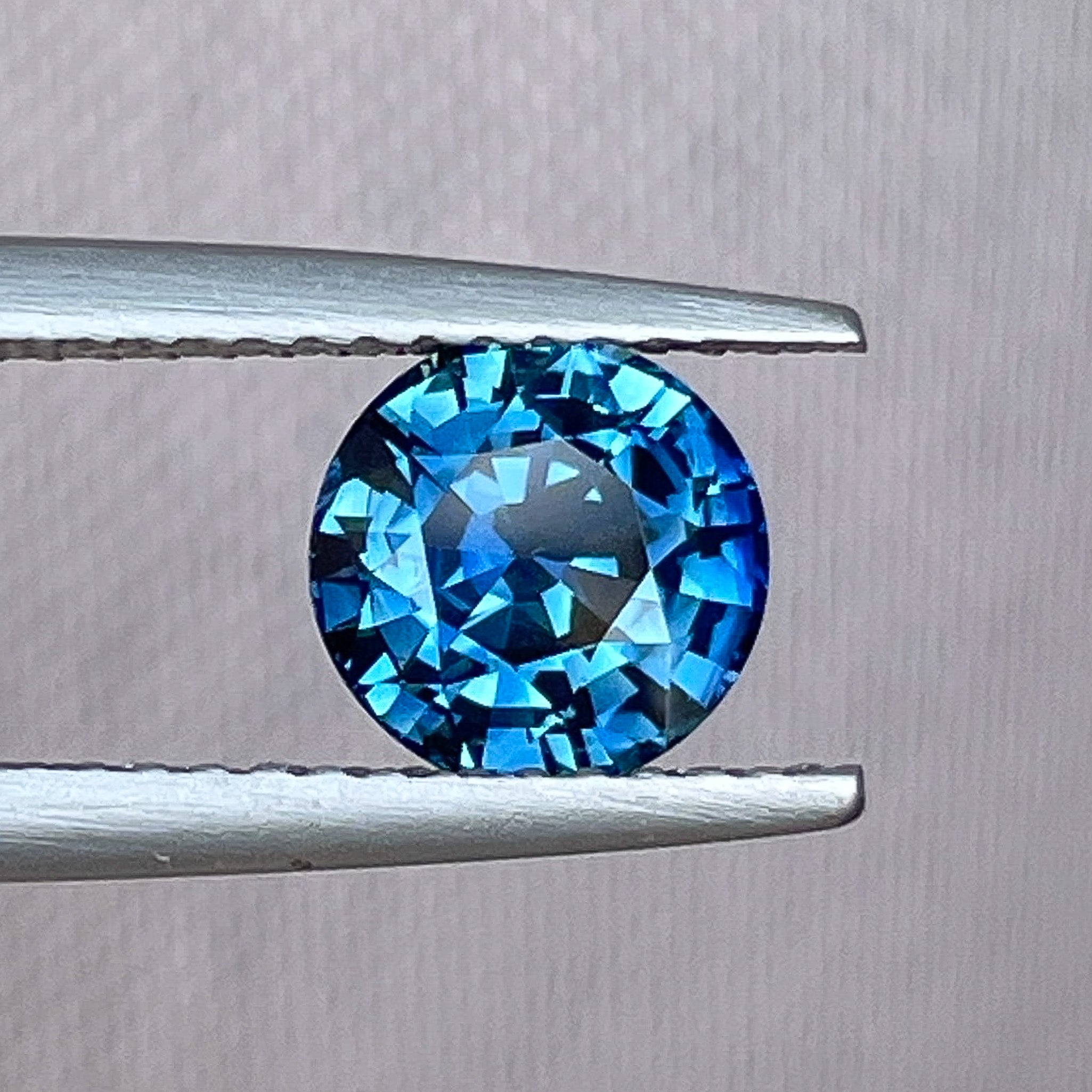 Natural teal blue sapphire 1.65 Ct round cut loose gemstone from NASHGEMS, ideal for engagement rings or custom jewelry.