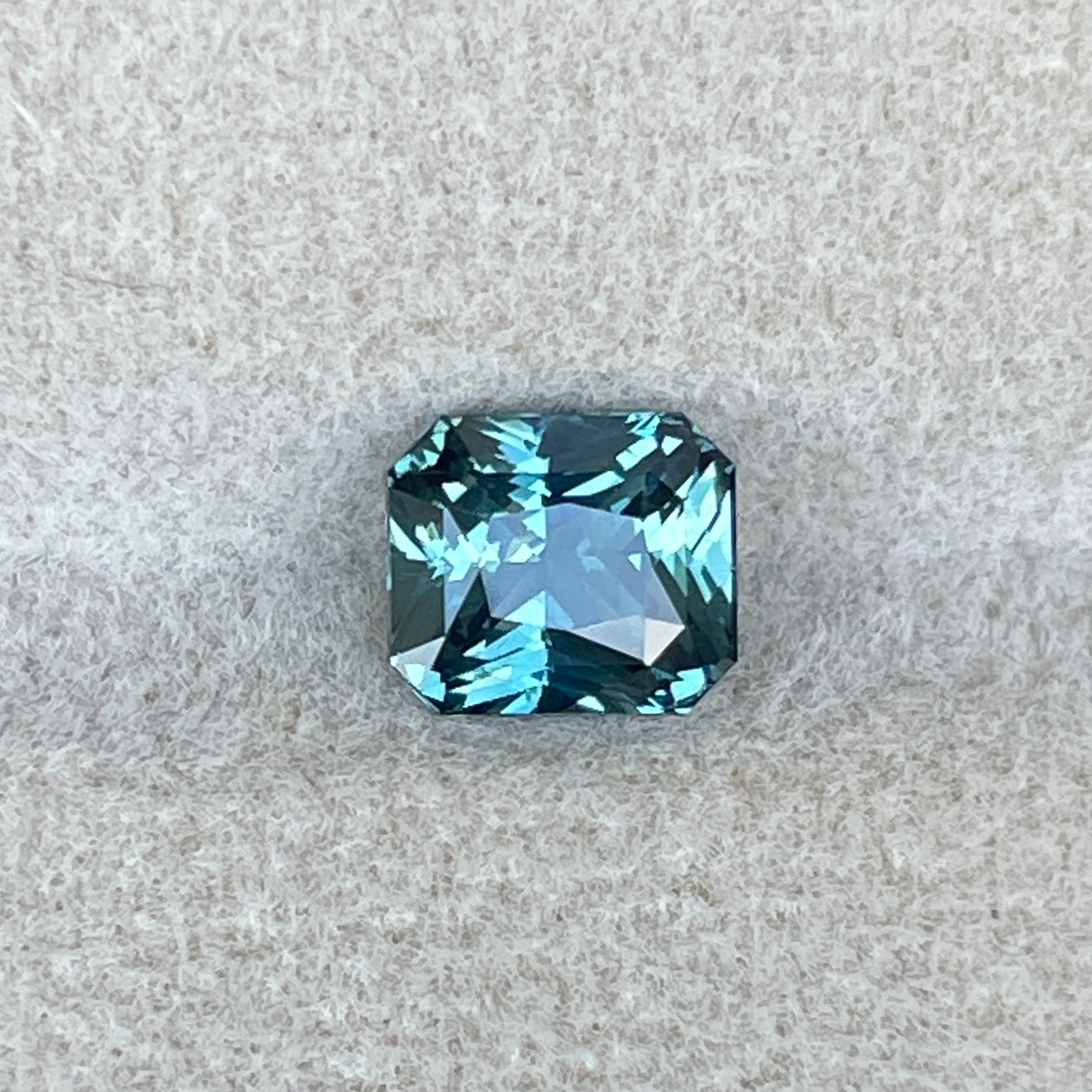 Natural teal sapphire by NASHGEMS, radiant cut 1.73 ct, loose gemstone ideal for engagement rings or custom jewelry.