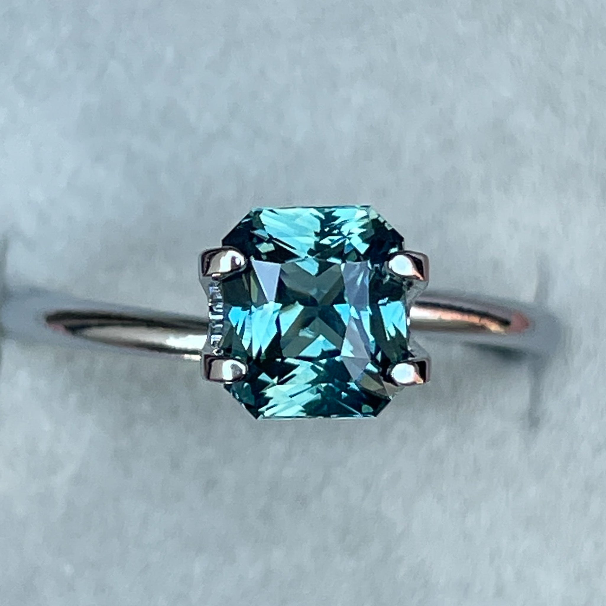Natural teal sapphire radiant cut 1.73 Ct from NASHGEMS, loose gemstone suitable for engagement rings or custom jewelry.