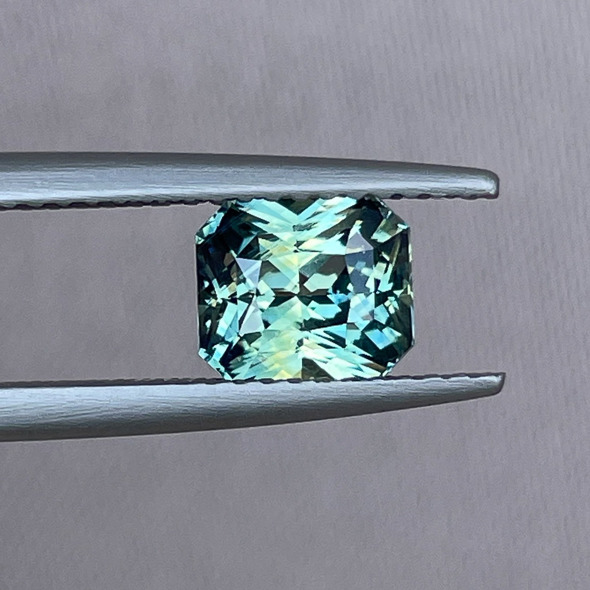 Teal sapphire loose gemstone with radiant cut, 1.65 carats, vibrant blue-green color, from NASHGEMS for engagement or jewelry making.