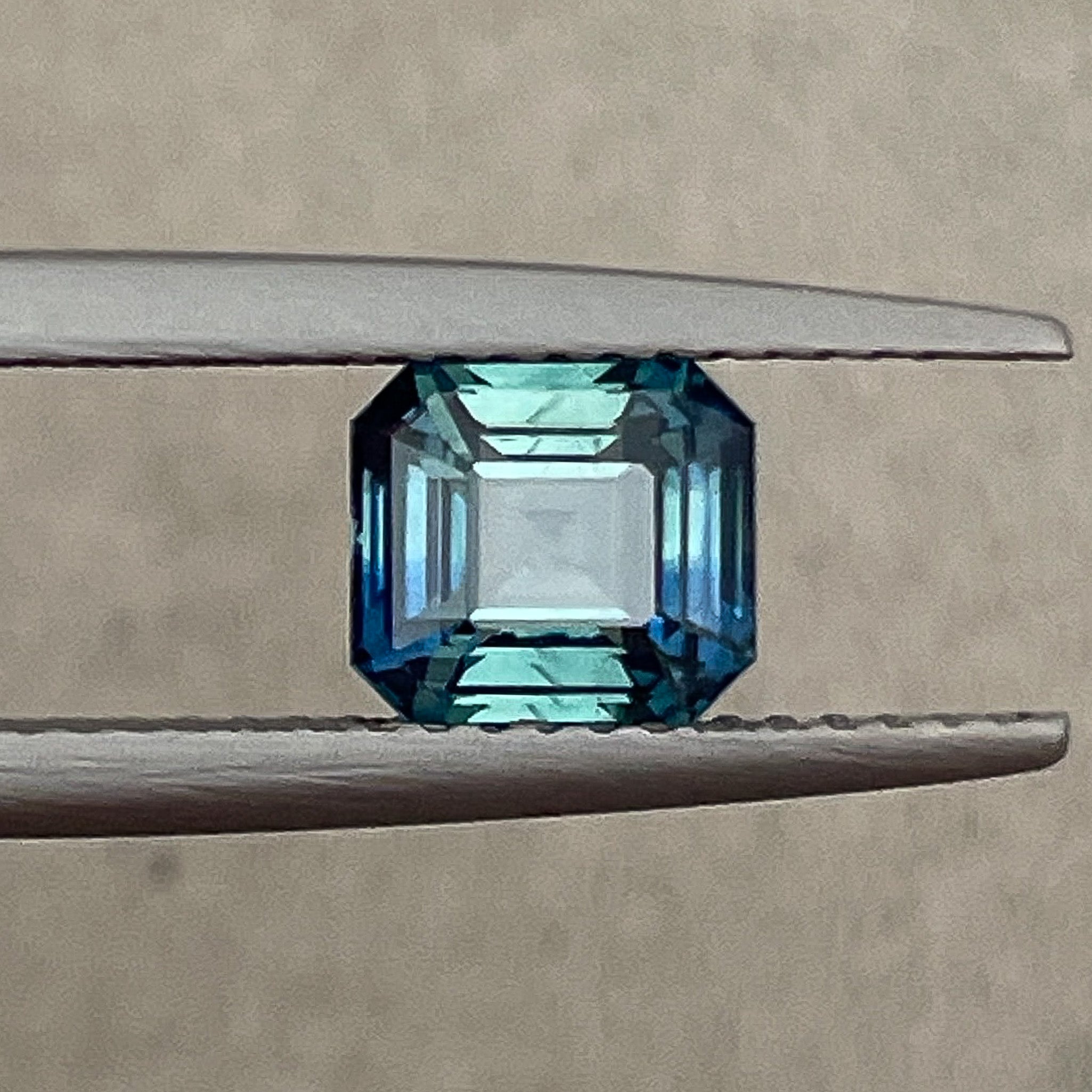 Natural teal blue-green sapphire 1.75 Ct loose emerald cut by NASHGEMS, showcasing vibrant bi-color sapphire for jewelry design