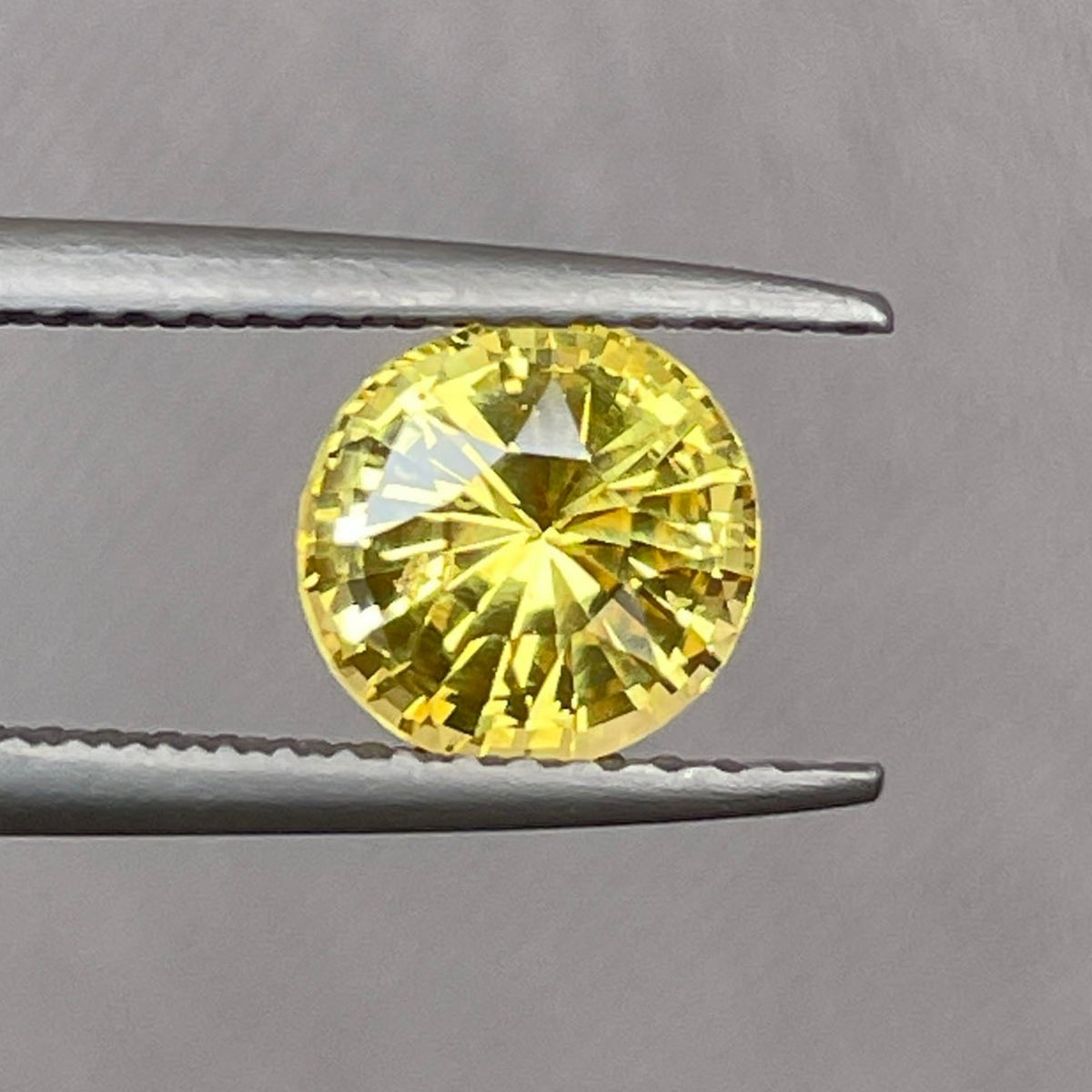 Natural yellow sapphire round cut 1.58 carat heat-treated loose gemstone for rings or pendants, showcasing vibrant yellow color and clarity.