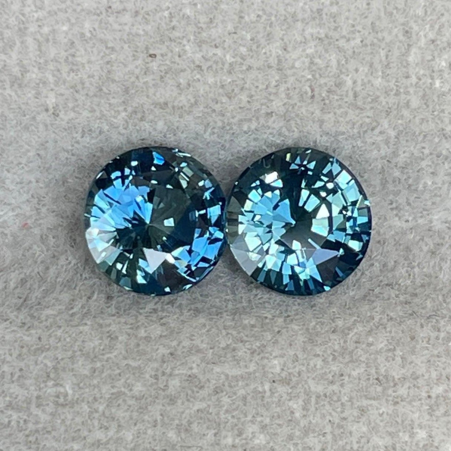 Pair of blue-green teal sapphire round gemstones from NASHGEMS, ideal for anniversary, Mother’s Day, or engagement jewelry.