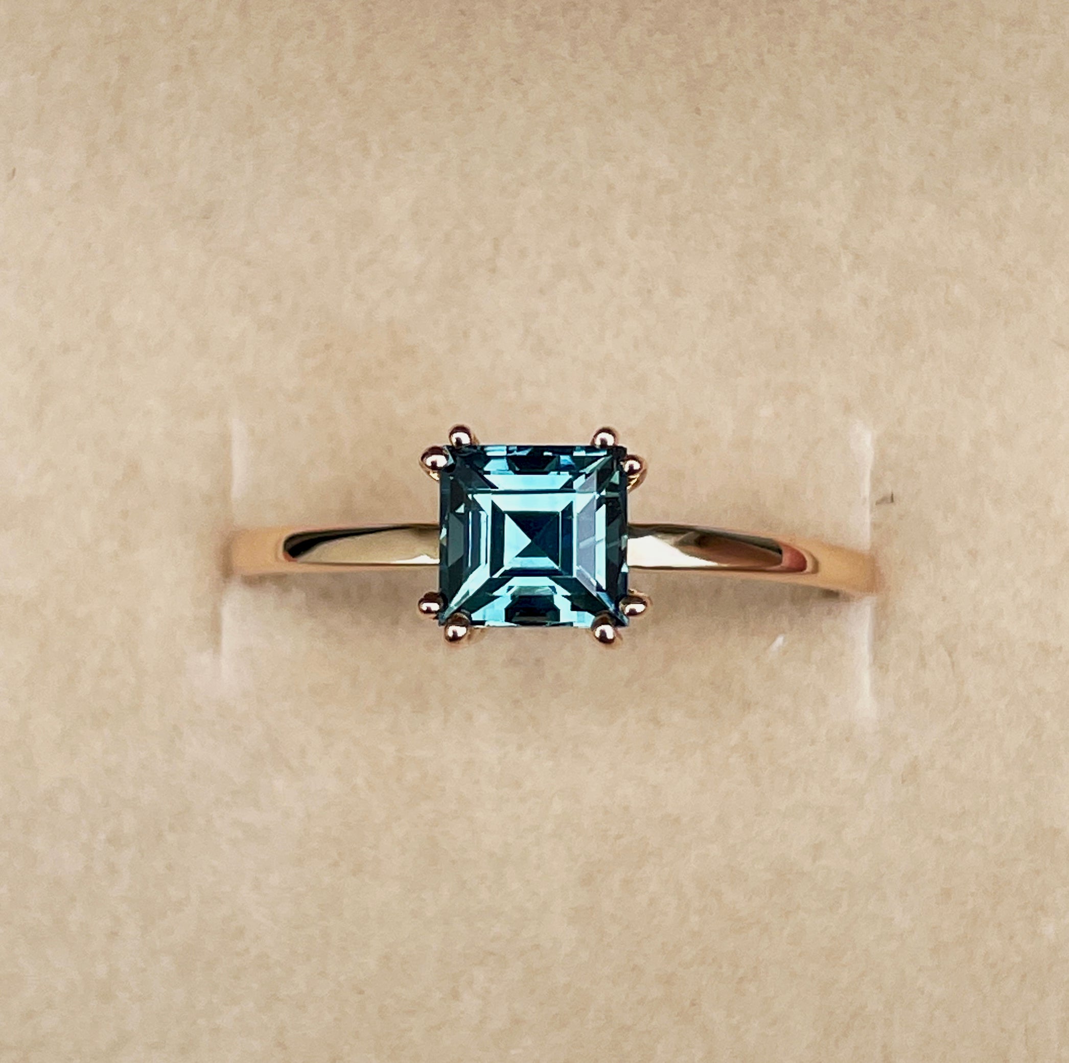 elegant ring features a 1.00 crt  Natural Teal Sapphire surrounded by sparkling CONFLICT-FREE natural white sapphire set in a solid 18k Rose Gold ring setting. The timeless and classic design of this ring will make your engagement unforgettable.
