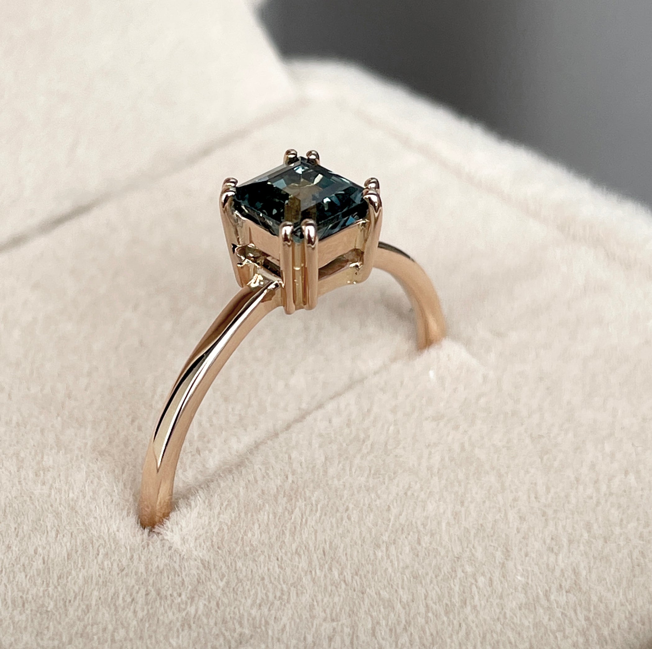 elegant ring features a 1.00 crt  Natural Teal Sapphire surrounded by sparkling CONFLICT-FREE natural white sapphire set in a solid 18k Rose Gold ring setting. The timeless and classic design of this ring will make your engagement unforgettable.