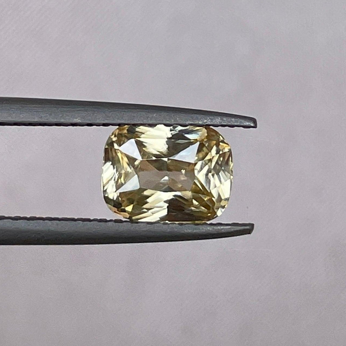 Natural yellow sapphire 1.60 ct. with yellowish peach hue from NASHGEMS, showcasing its vibrant color and smooth cut.