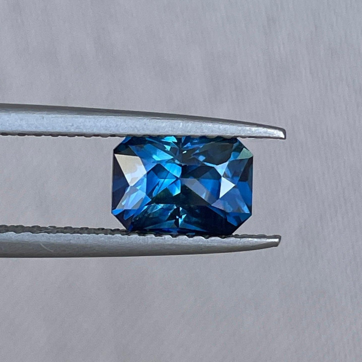 Teal sapphire anniversary ring with radiant cut, 1.69 carats, featuring blue-green sapphire jewelry by NASHGEMS for engagement.