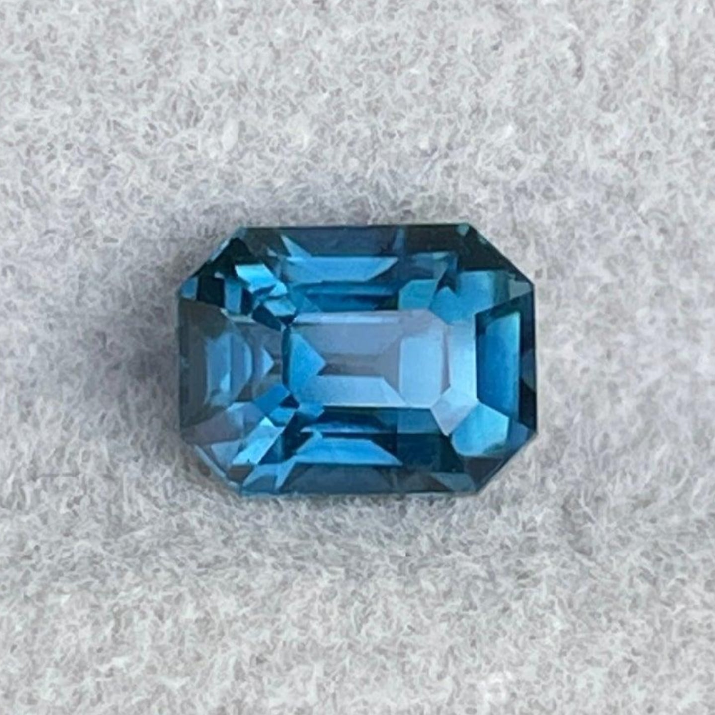 Teal sapphire precious stone with emerald cut, 1.25 carats, from NASHGEMS, suitable for engagement rings or green gemstone jewelry.