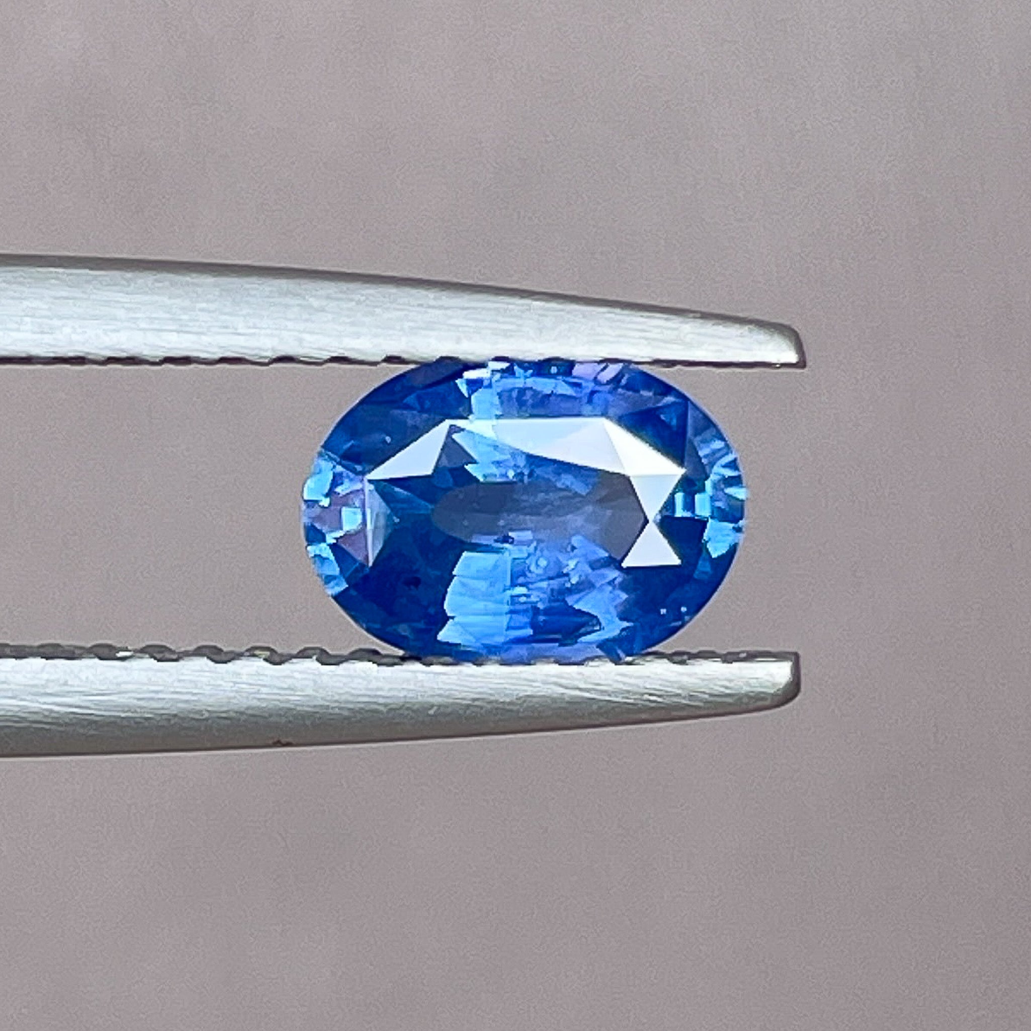 Natural Ceylon Blue Sapphire 0.97 Ct oval cut loose gemstone by NASHGEMS, showcasing vibrant blue color and polished surface.