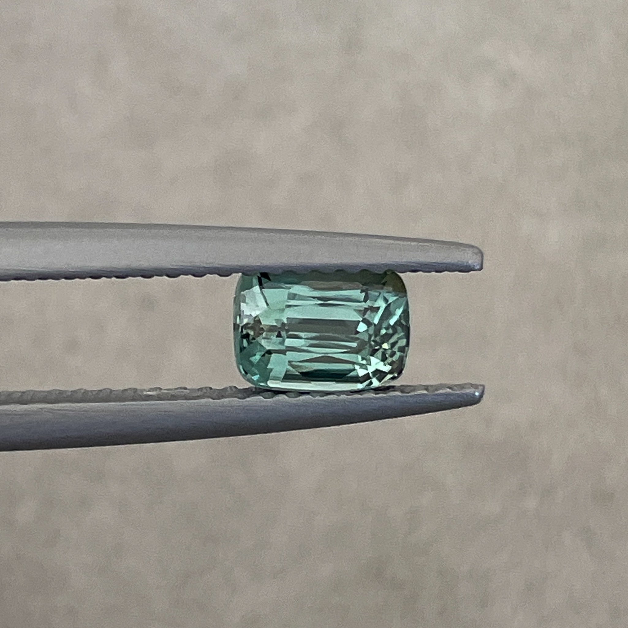 Natural teal green sapphire, 1.03 ct cushion cut loose gemstone by NASHGEMS, perfect for engagement rings or custom jewelry.