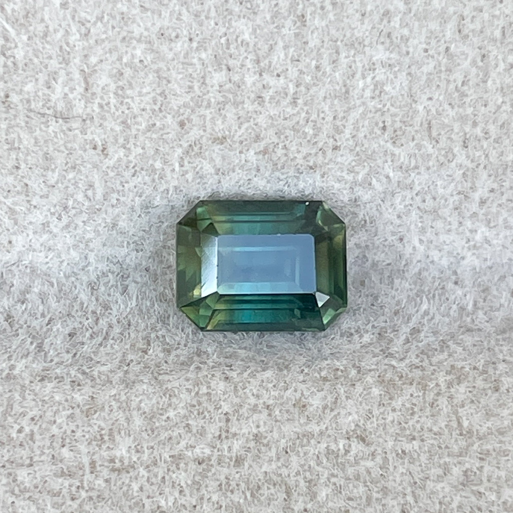 Teal natural bi-color sapphire, 1.13 ct emerald cut loose gemstone by NASHGEMS, ideal for engagement rings or custom jewelry.