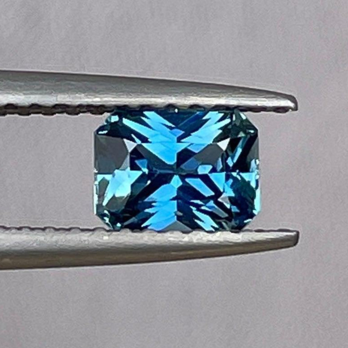 Loose teal sapphire gemstone in radiant cut, 0.84 carats, showcasing vibrant teal color ideal for engagement or anniversary rings.