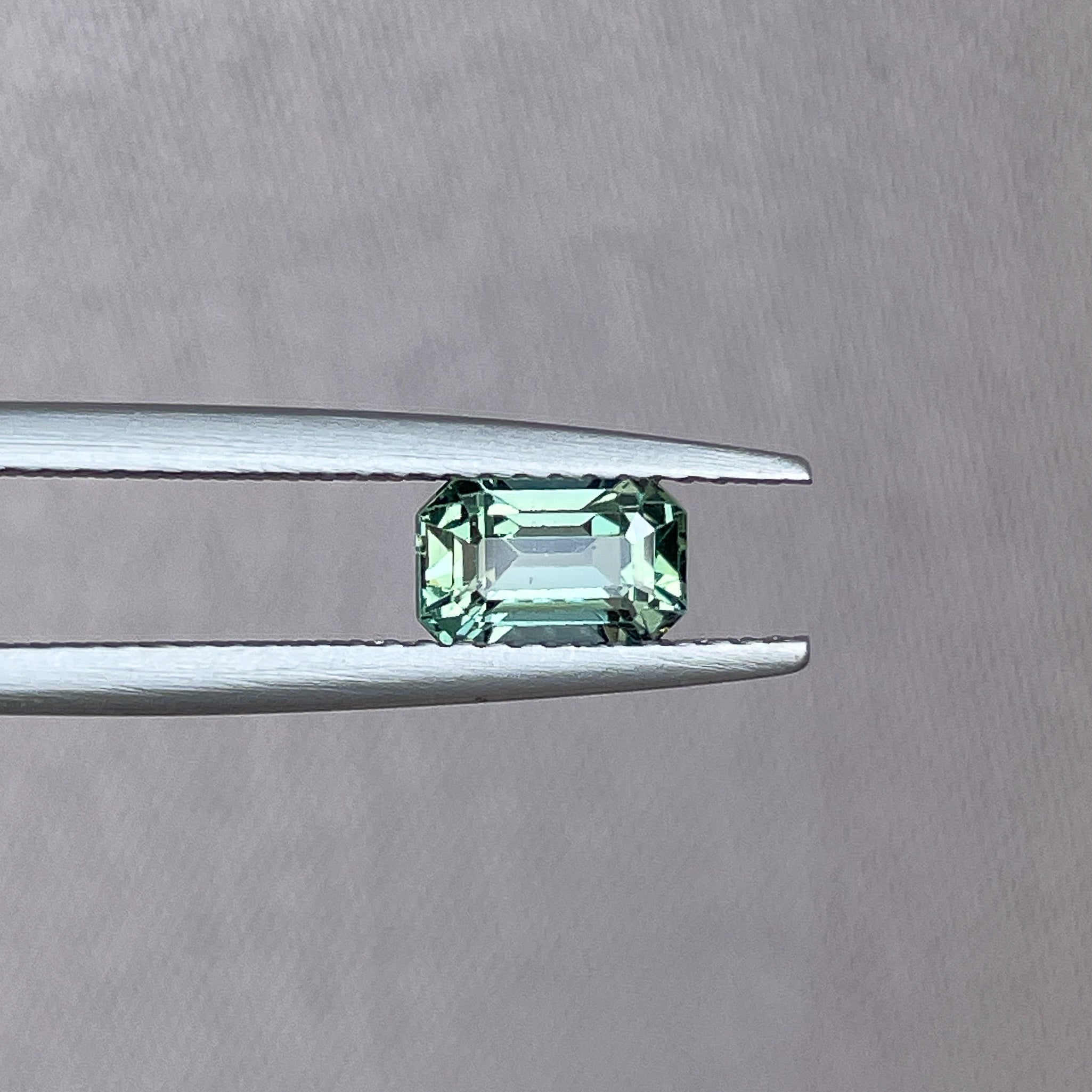 Natural pale green teal sapphire, 1.24 ct emerald cut, loose gemstone by NASHGEMS for engagement or custom jewelry.