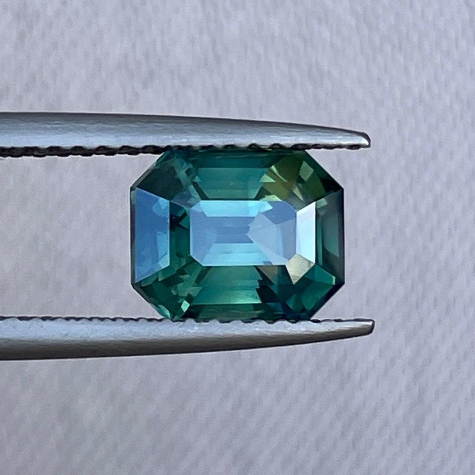 Teal blue and green gemstone sapphire emerald cut engagement ring with 2.55 carats, featuring a September birthstone by NASHGEMS.