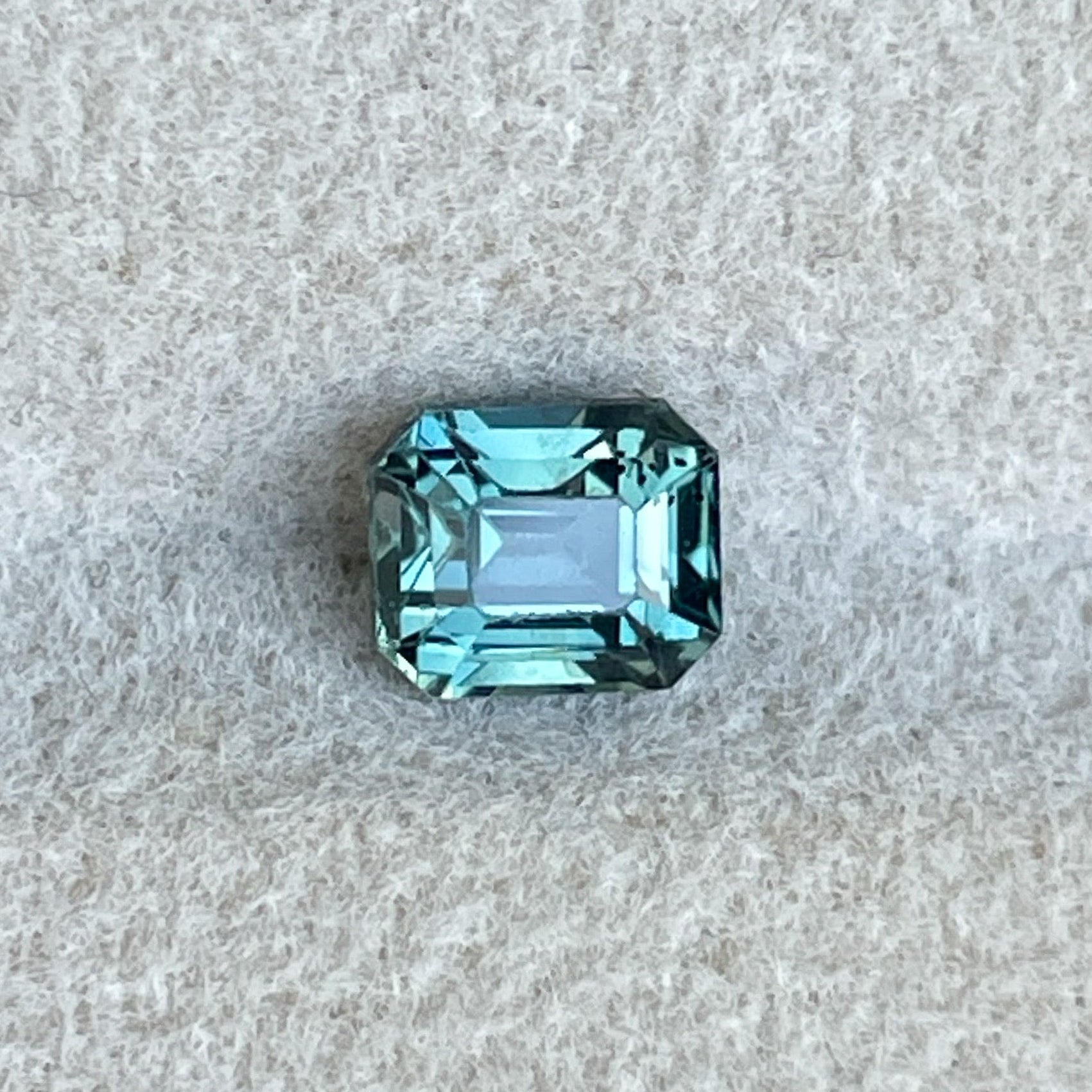 Natural teal sapphire from NASHGEMS, 1.05 Ct emerald cut loose gemstone with blue-green hues for jewelry making or engagement rings.