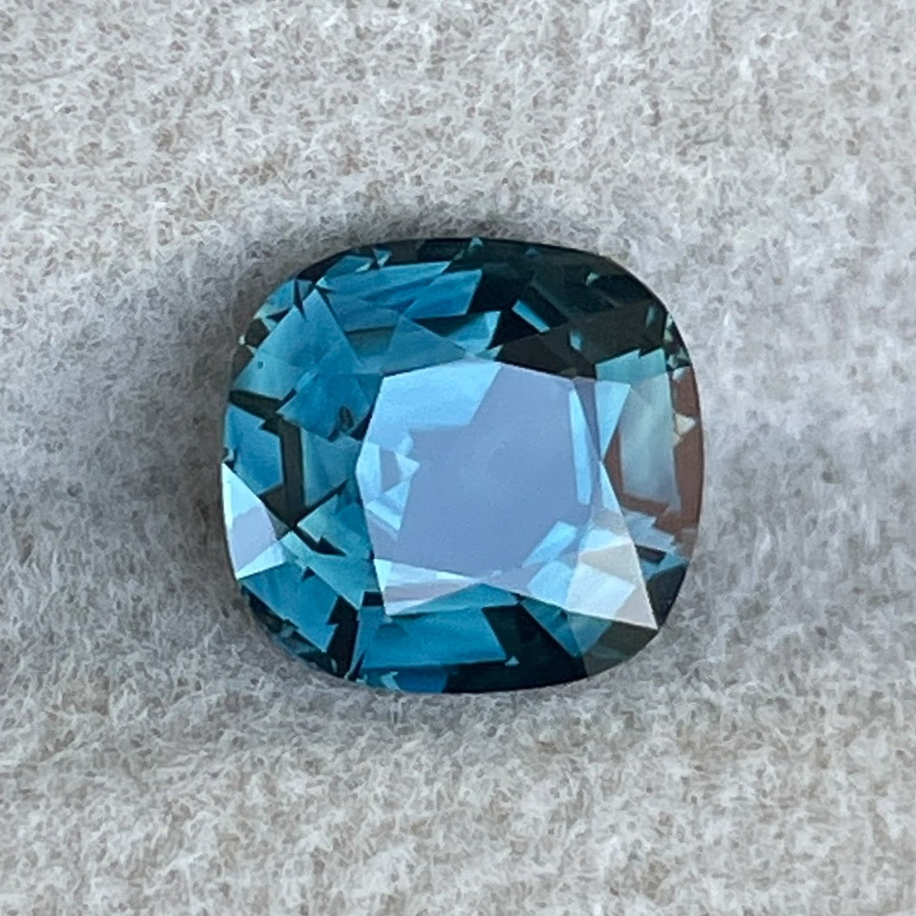 NASHGEMSのナチュラルティールサファイア2.02カラット、クッションカットのルースジェムストーン。婚約指輪やカスタムジュエリーに最適です。