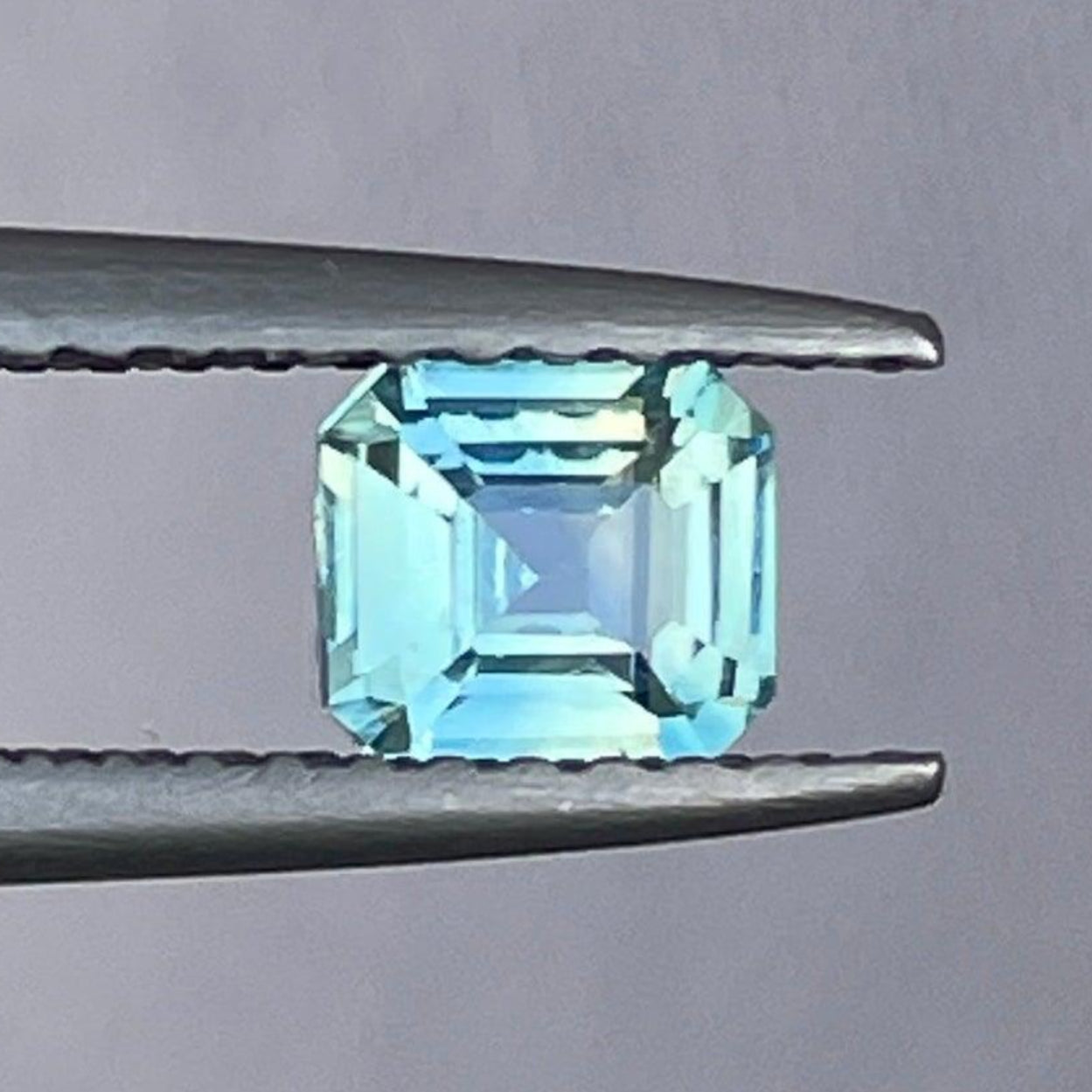 Natural unheated bi-color teal sapphire, 0.57 carats, from NASHGEMS, showcasing vibrant color and faceted gemstone detail.