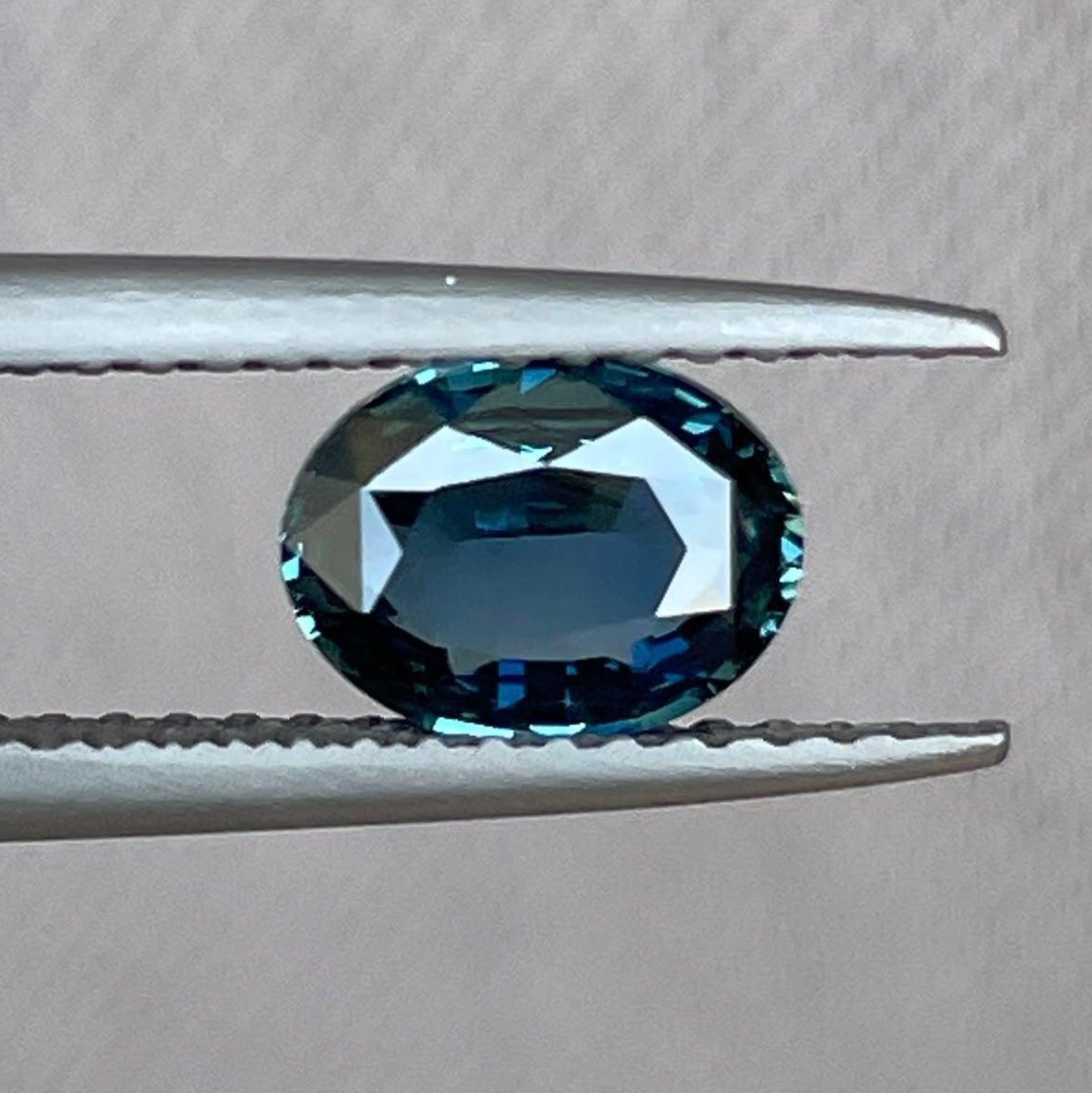 Teal sapphire gemstone with vibrant color and excellent cut, showcasing rich blue-green hues and natural luster.