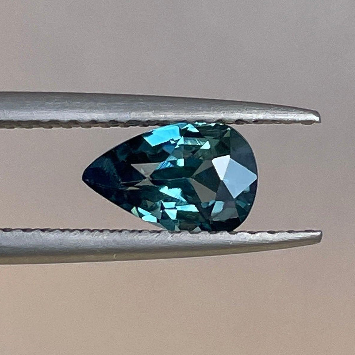 Teal sapphire pear cut gemstone, 0.93 carats, from NASHGEMS, showcasing vibrant teal color and elegant cut.