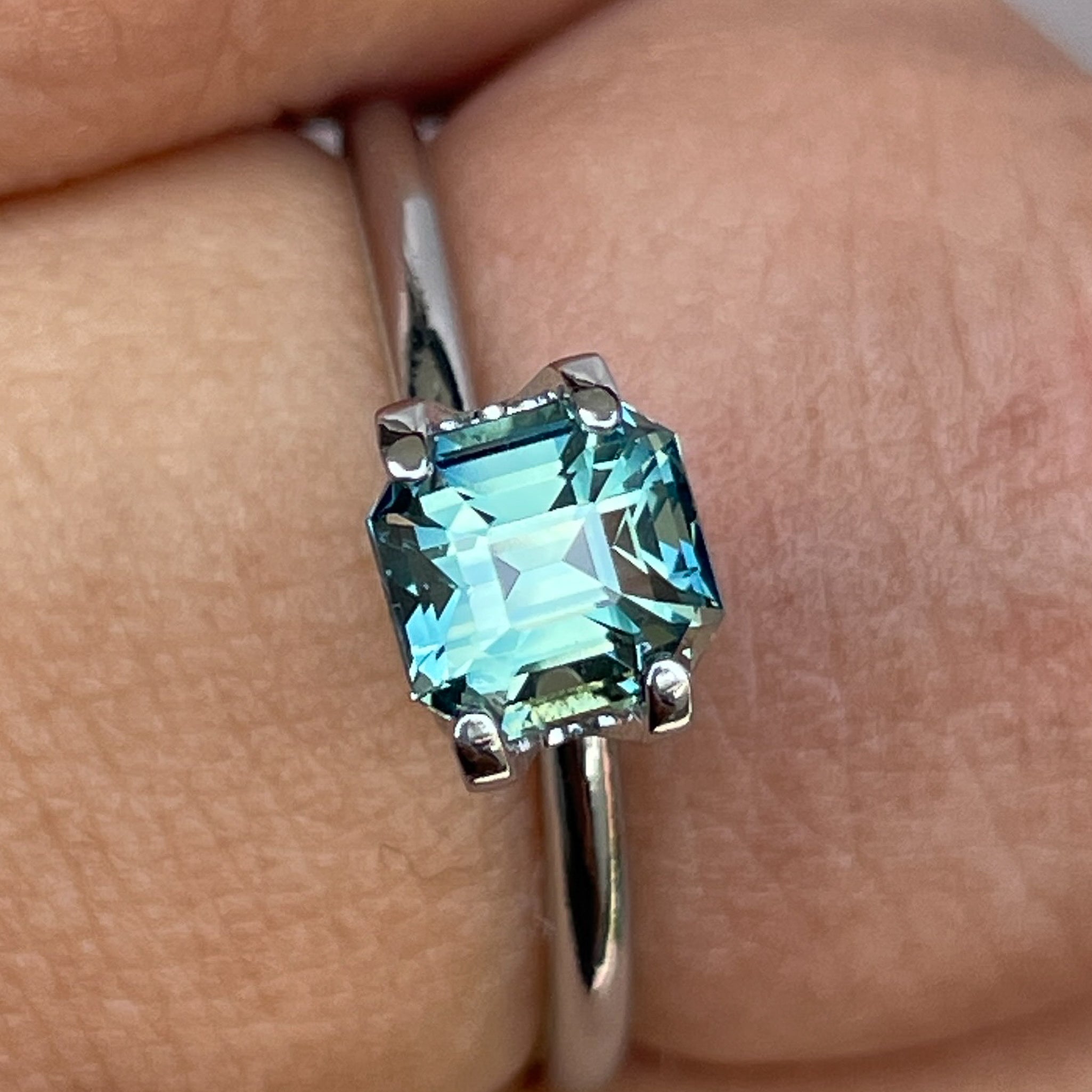 Natural teal green sapphire, 1.36 Ct emerald cut, loose gemstone from NASHGEMS, ideal for engagement rings or custom jewelry.