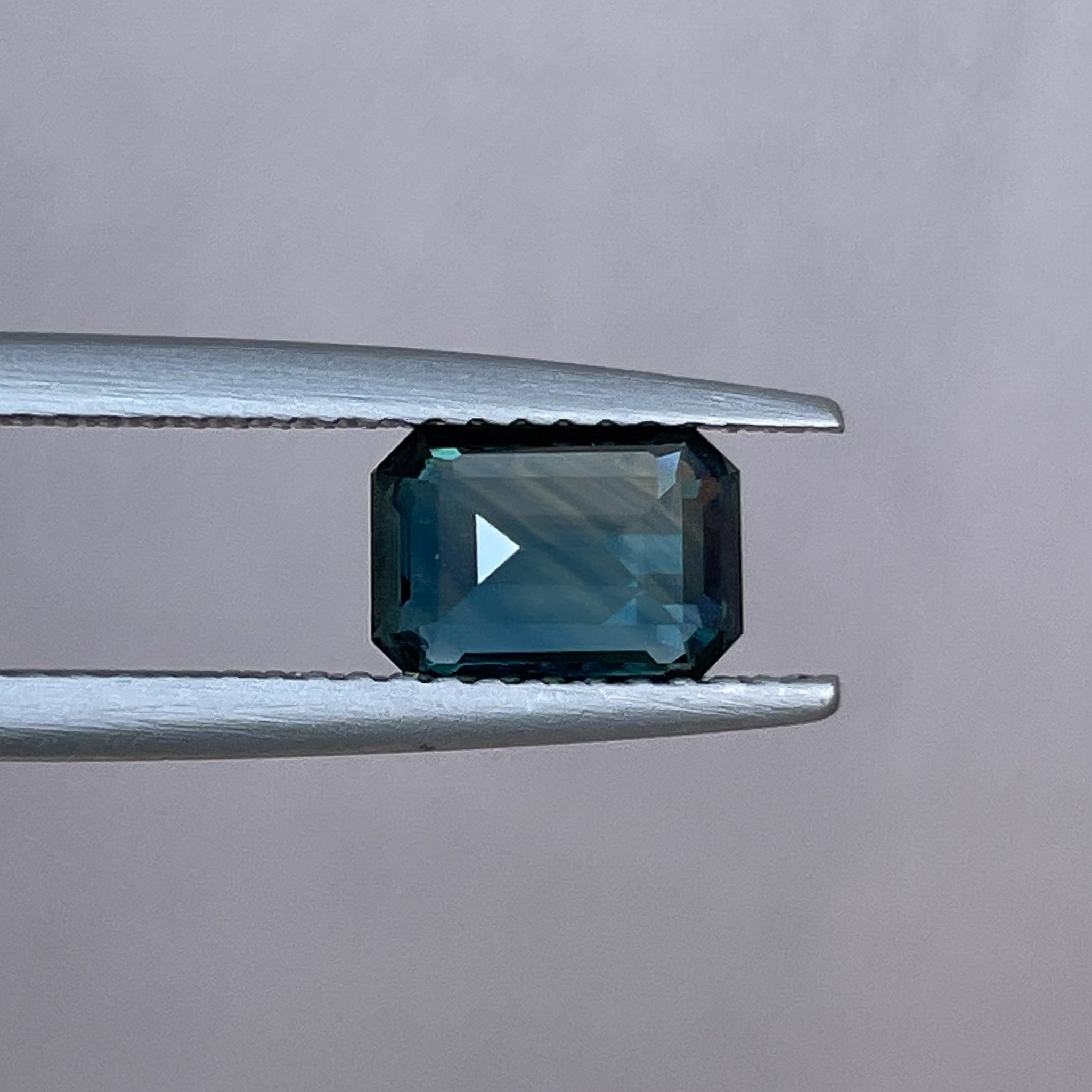 Natural NASHGEMS teal sapphire loose stone, 1.52 Ct emerald cut with blue-green hues, ideal for engagement or custom jewelry.