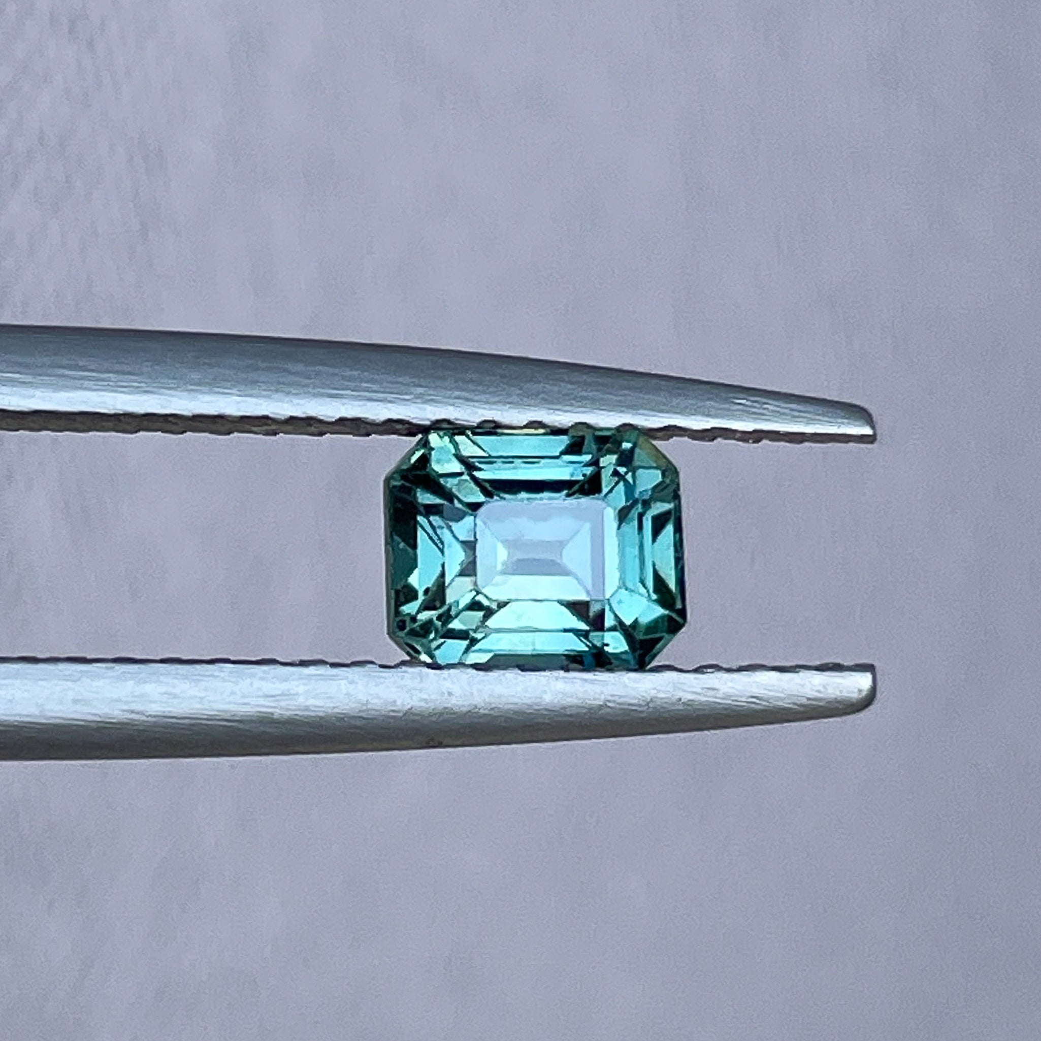 Natural teal sapphire loose stone, 1.05 ct emerald cut in blue-green hues, ideal for engagement rings or custom jewelry.