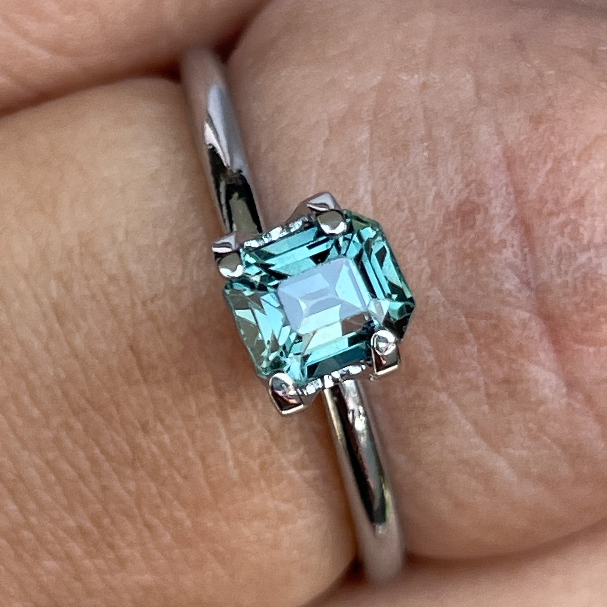 Natural teal sapphire loose stone, 1.05 Ct emerald cut by NASHGEMS, showcasing vibrant blue-green hues for jewelry creation.