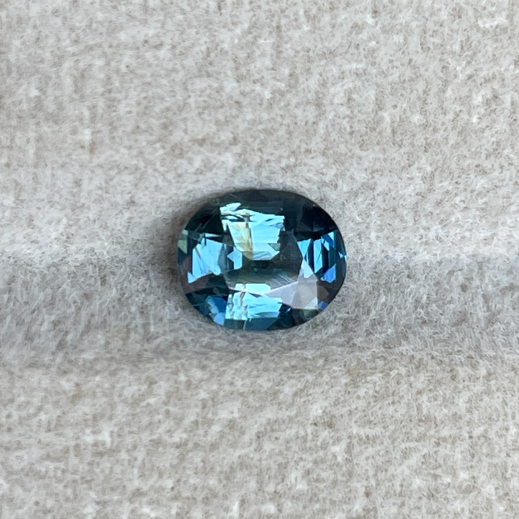 Natural teal sapphire 1.03 Ct oval cut loose gemstone by NASHGEMS, featuring vibrant teal blue-green color for jewelry making.