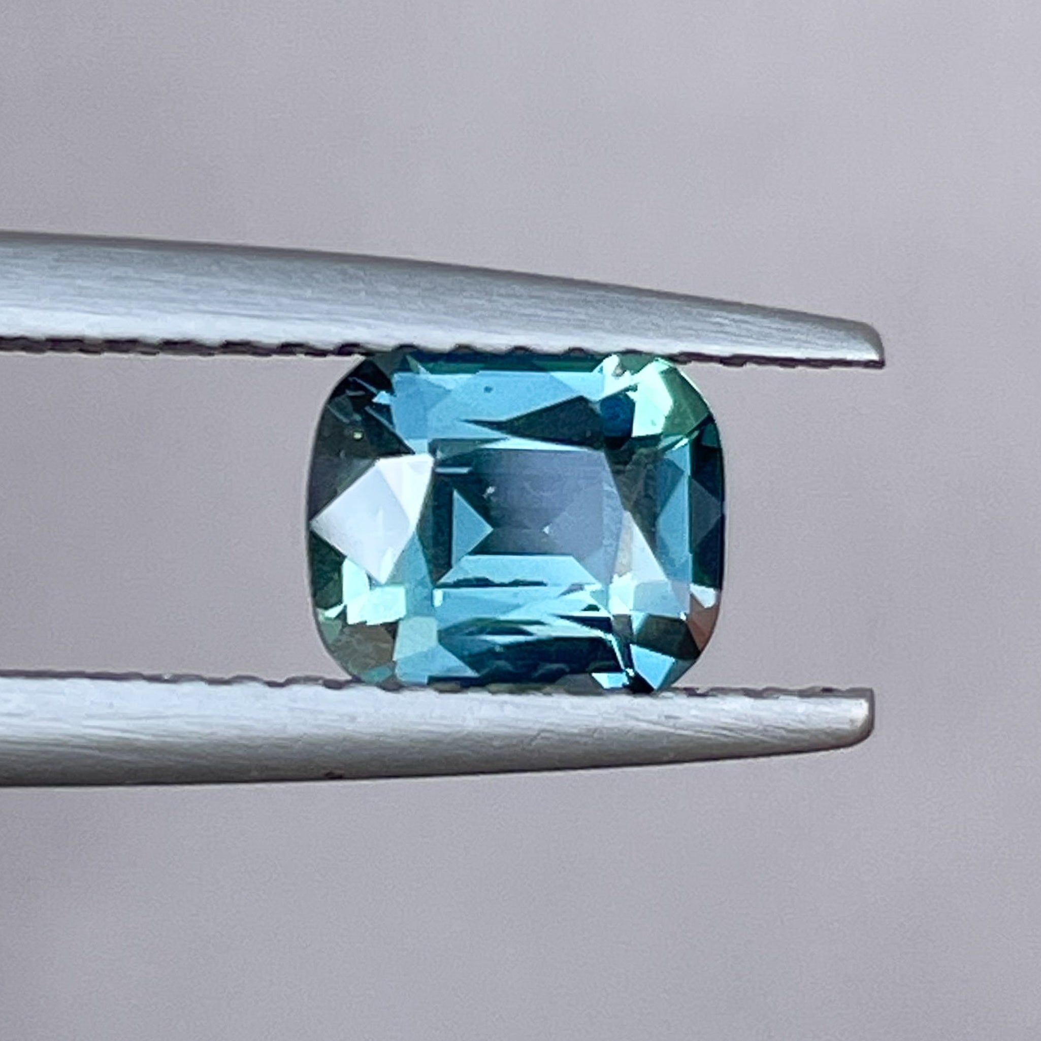 Natural teal blue sapphire 1.18 ct cushion cut loose gemstone by NASHGEMS, perfect for engagement rings or custom jewelry.